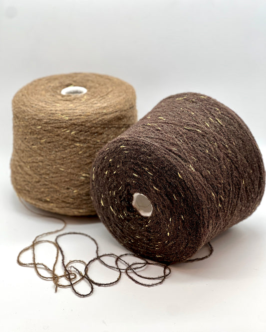 Two spools of brown yarn on a white background