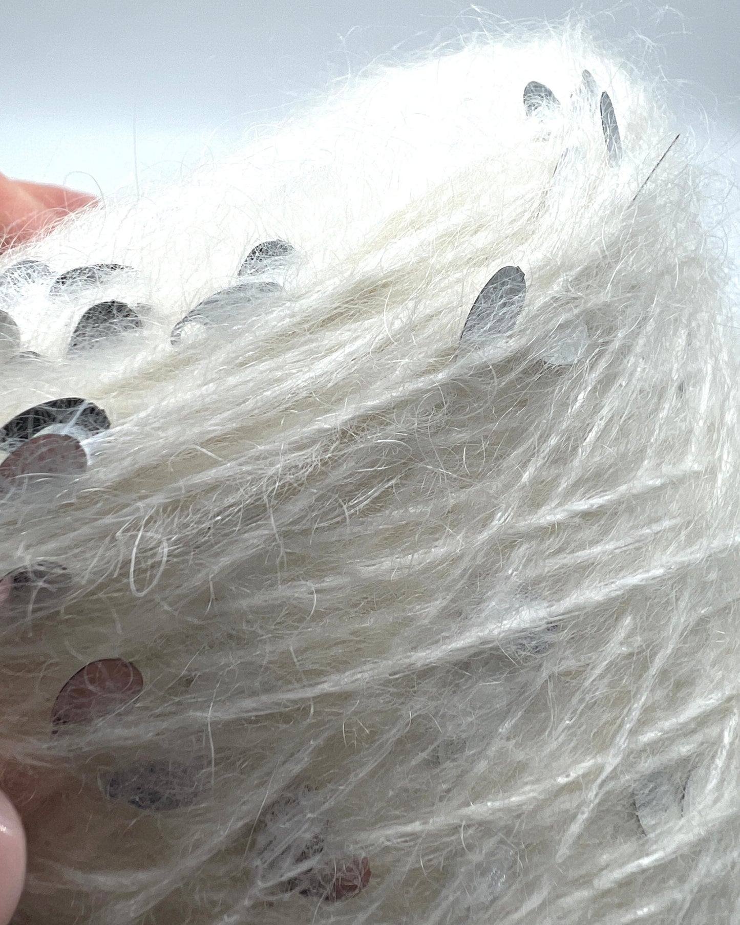 Close-up of a white plastic bag with small holes and a metallic object inside.