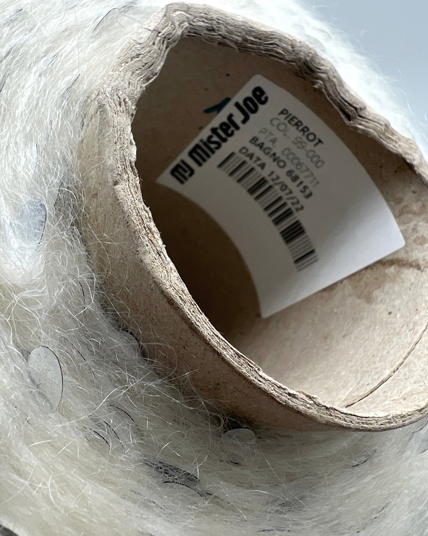 Roll of paper towel with a label inside, partially wrapped in plastic.
