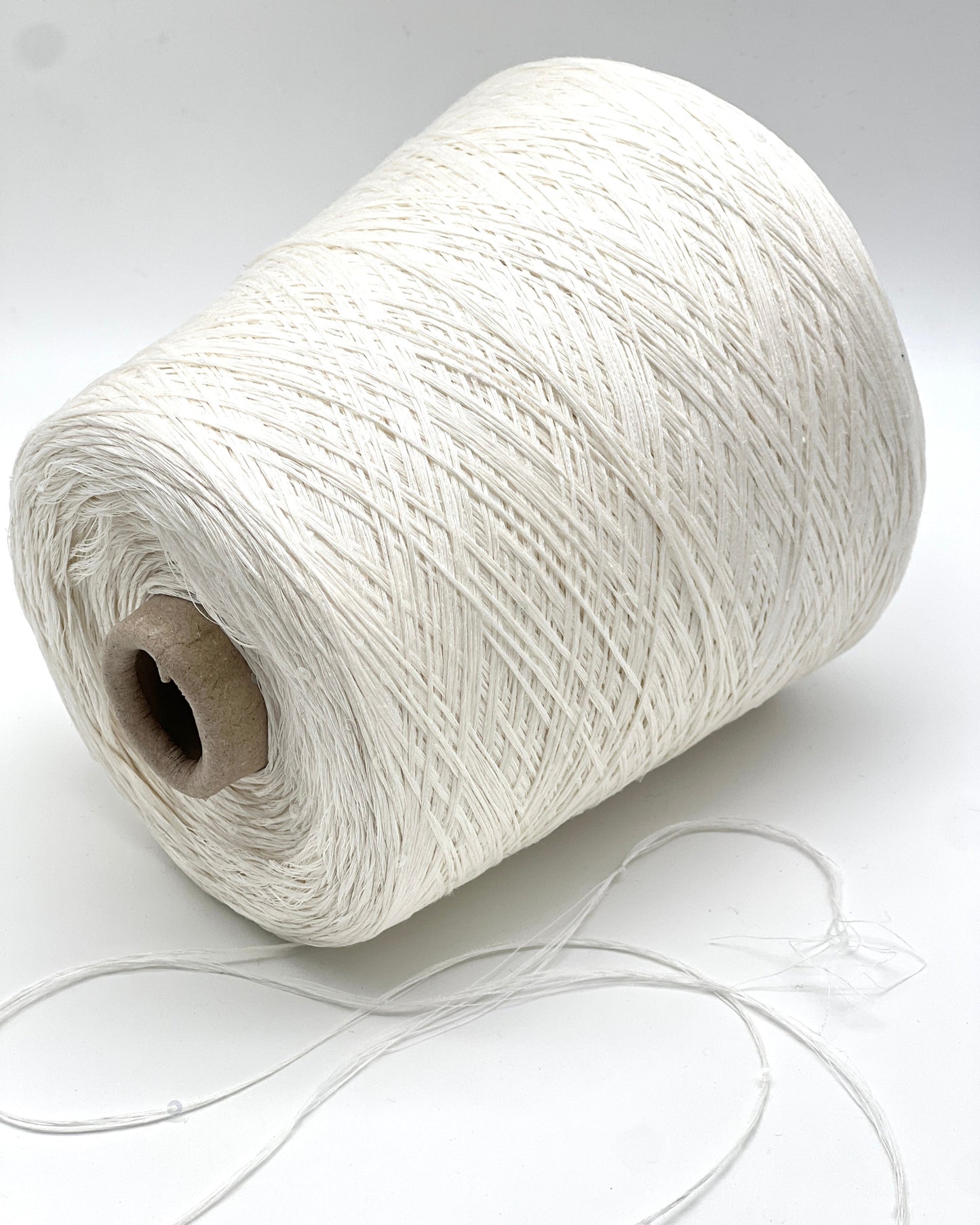 Spool of white yarn on a white background