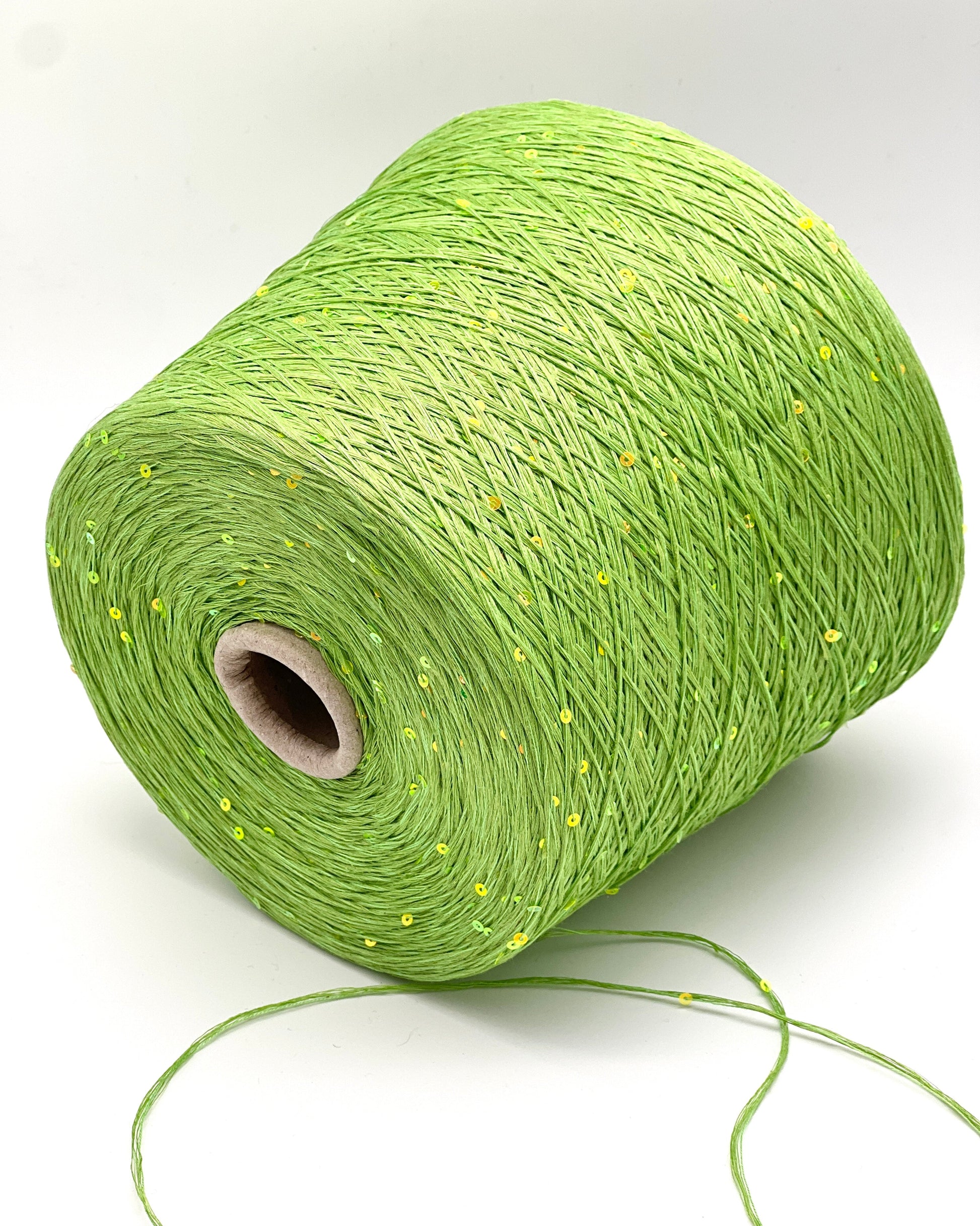 Green spool of yarn on a white background