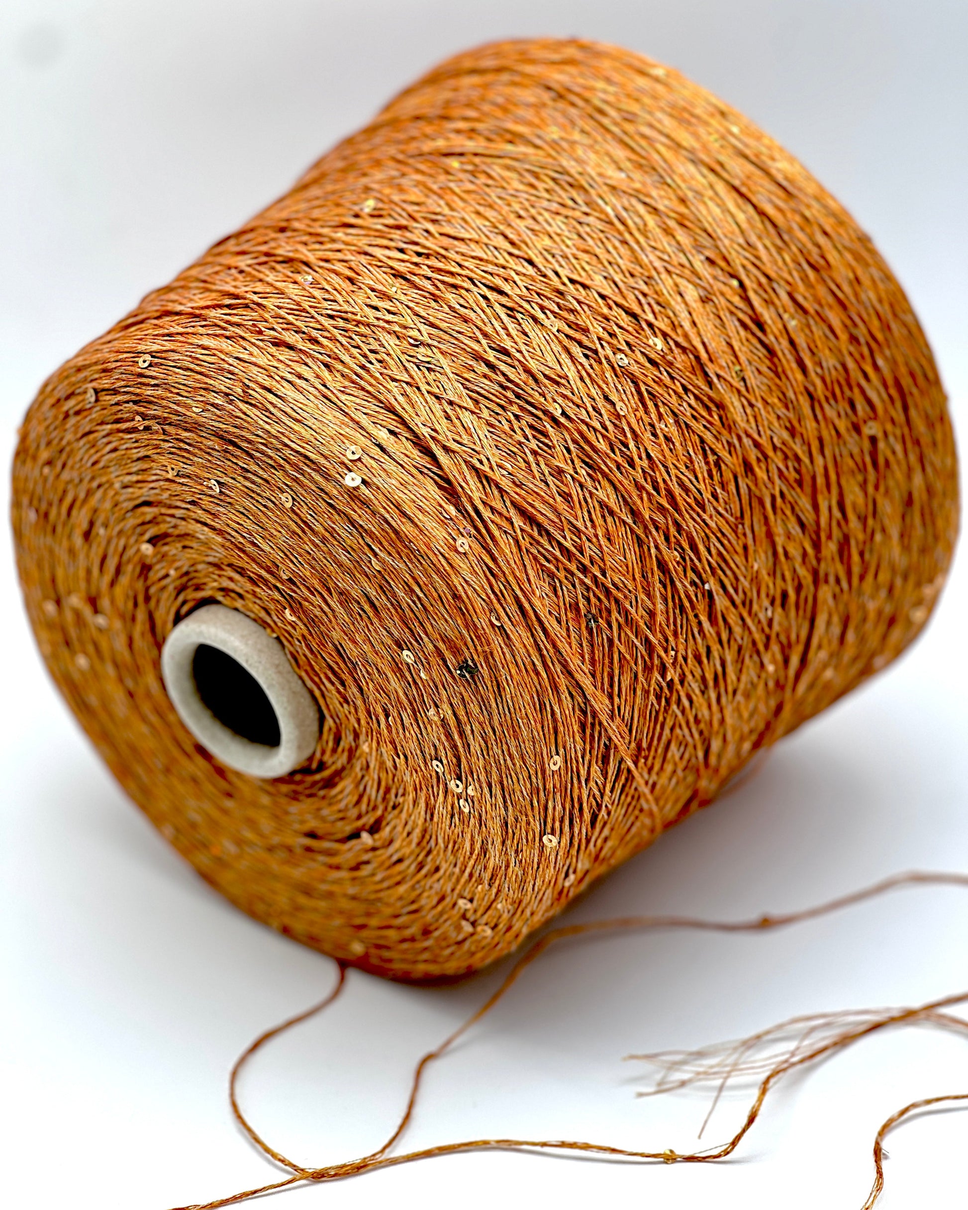 Spool of brown thread on a white background