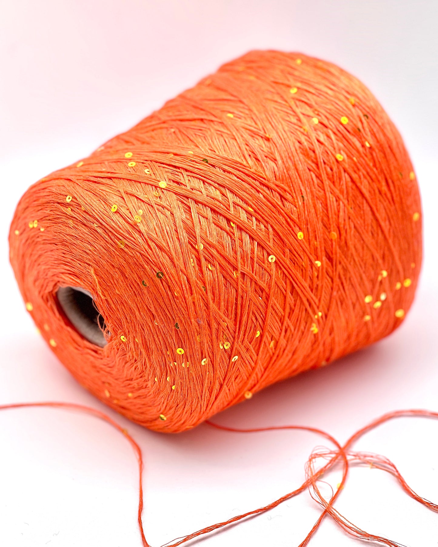 Orange spool of thread on a white background