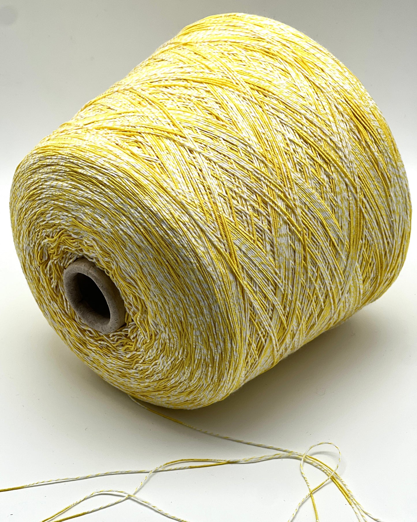 Spool of yellow thread on a white background