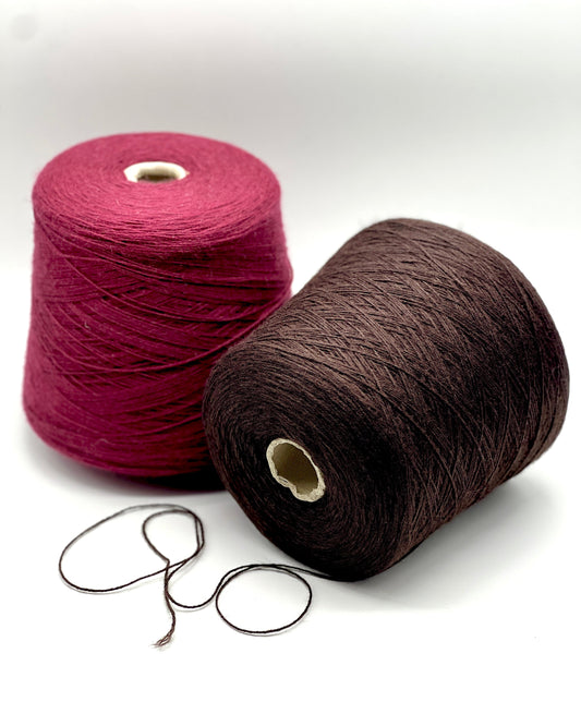 Two spools of yarn, one pink and one brown, on a white background.