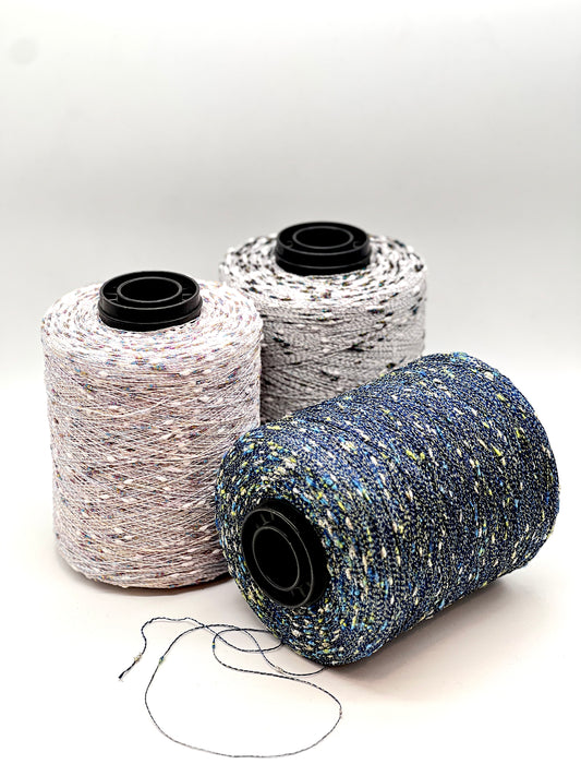 Three spools of thread in different colors on a white background