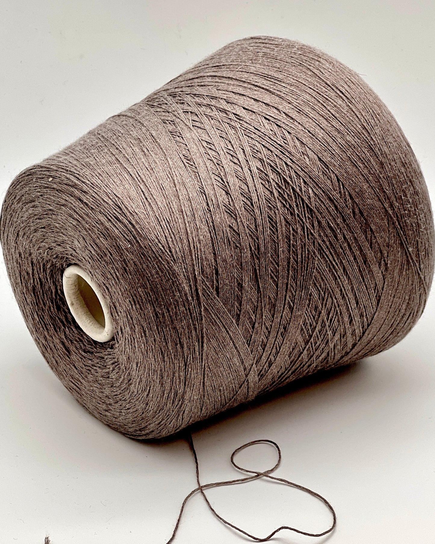Large spool of brown thread on a white background
