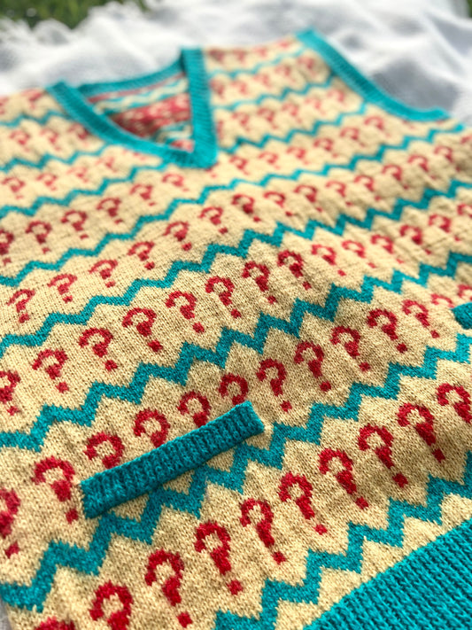 Knitted sweater with red question mark pattern and turquoise accents