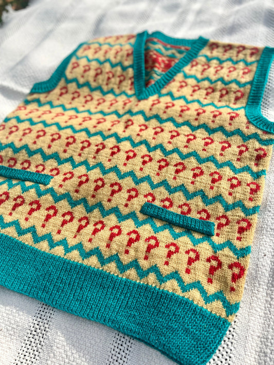 Knitted baby sweater with question mark pattern on a white background