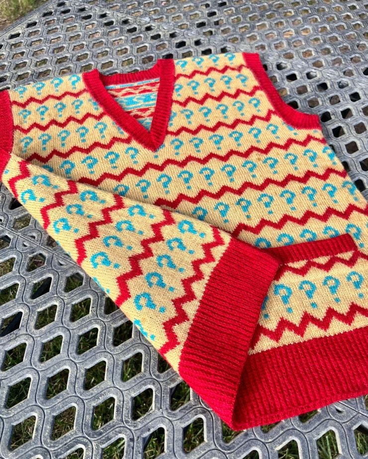 Colorful knitted sweater with zigzag pattern on a metal surface