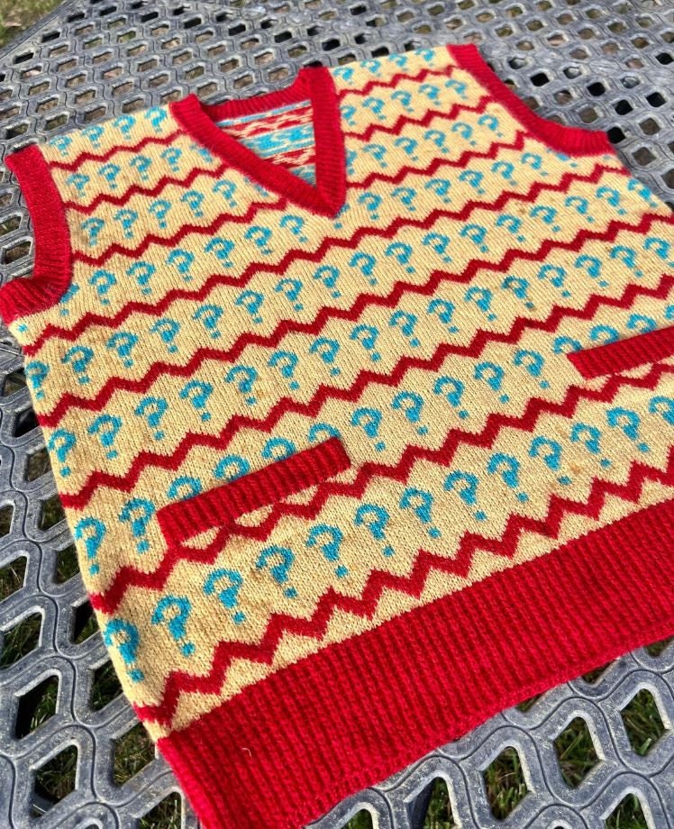 Knitted sweater with red and yellow pattern on a metal surface