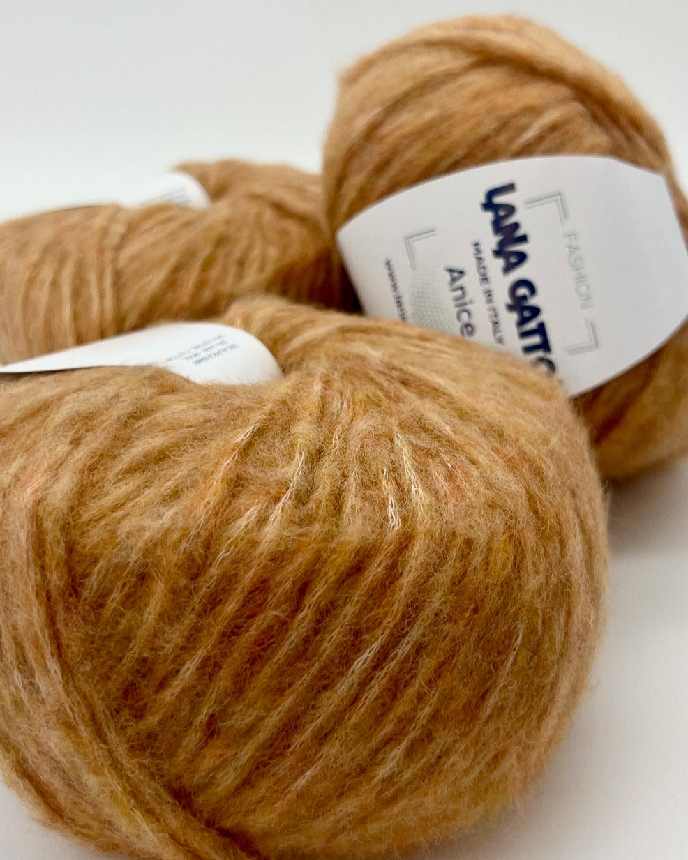 Two skeins of brown yarn with labels on a white background