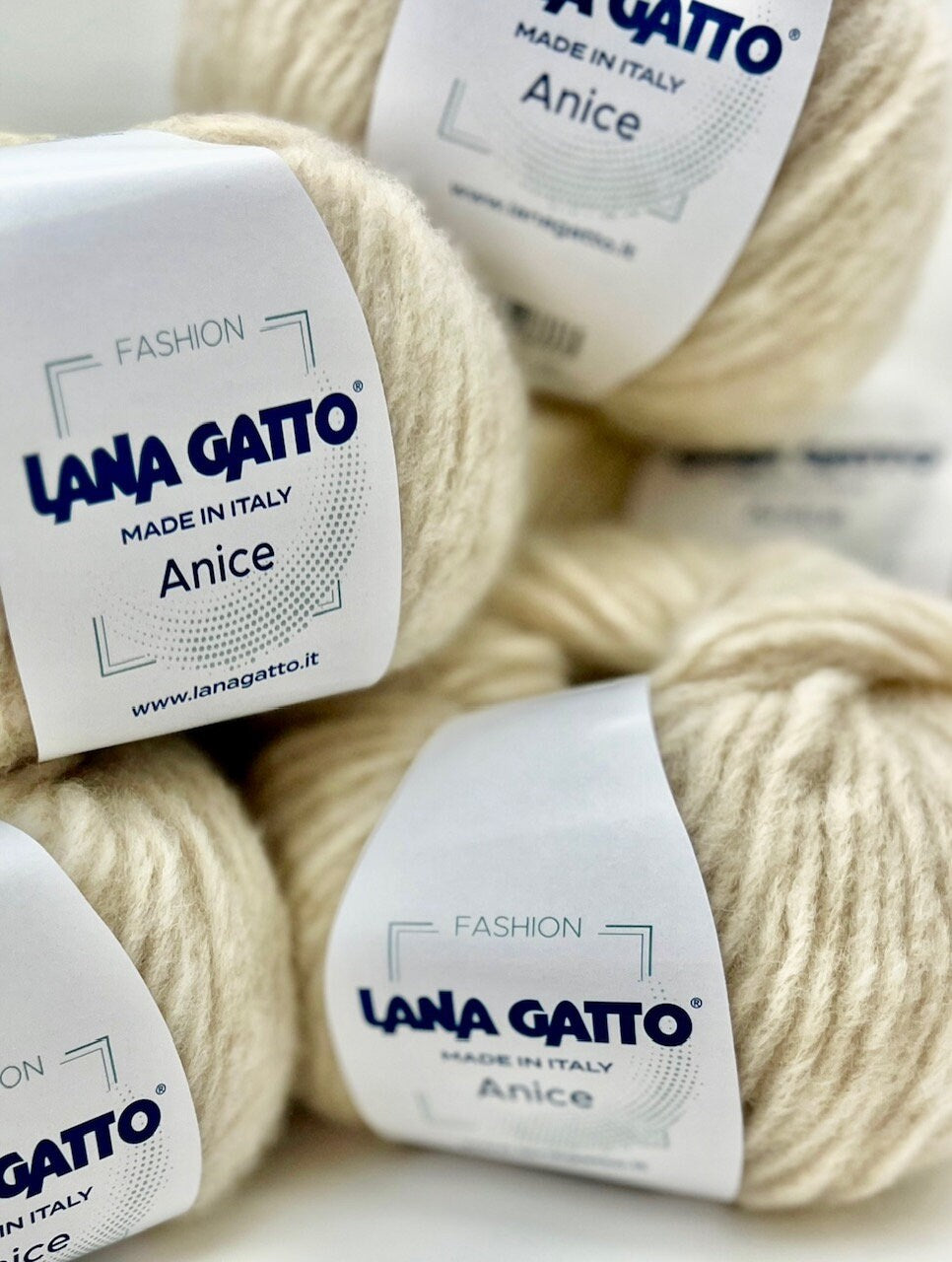 Yarn balls with 'Lana Gatto' labels on a light background