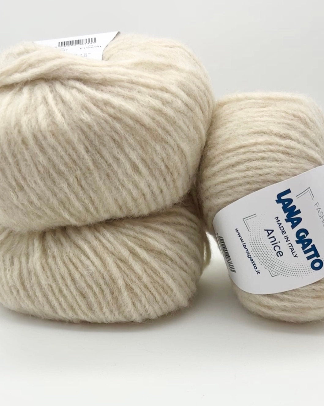 Two balls of cream-colored yarn with 'Lana Grossa' labels on a white background