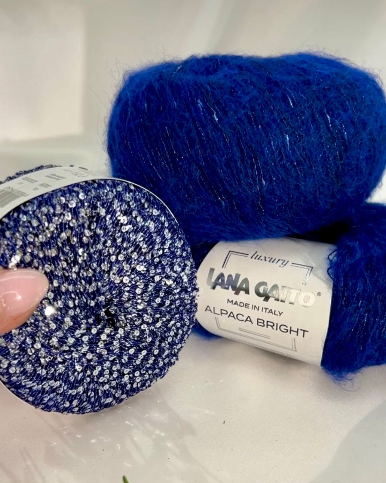 Two skeins of blue yarn with labels on a white background