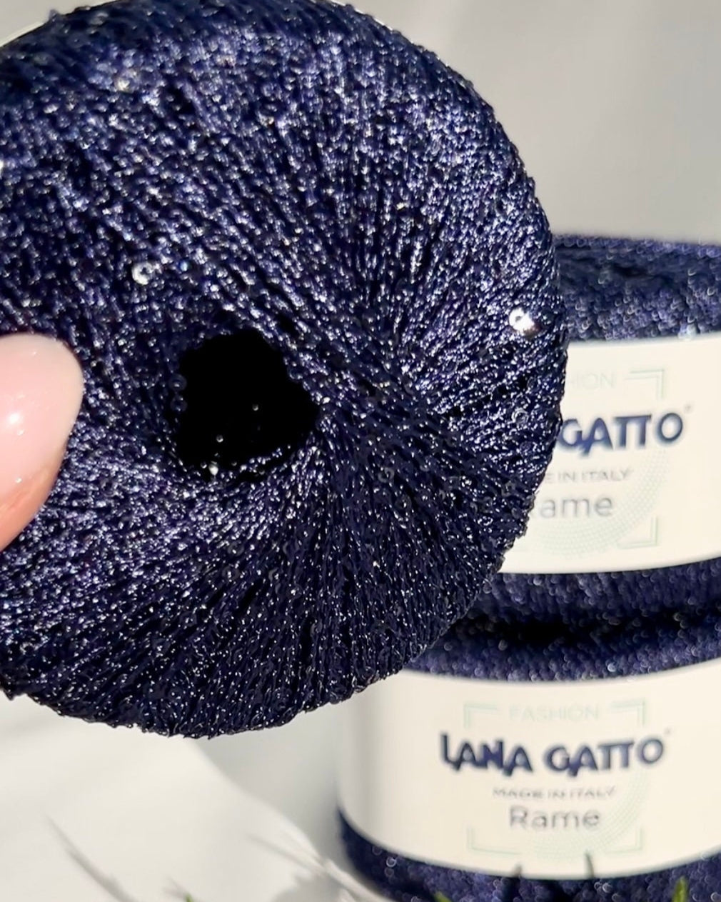 Navy blue yarn ball with a visible brand label on a white background