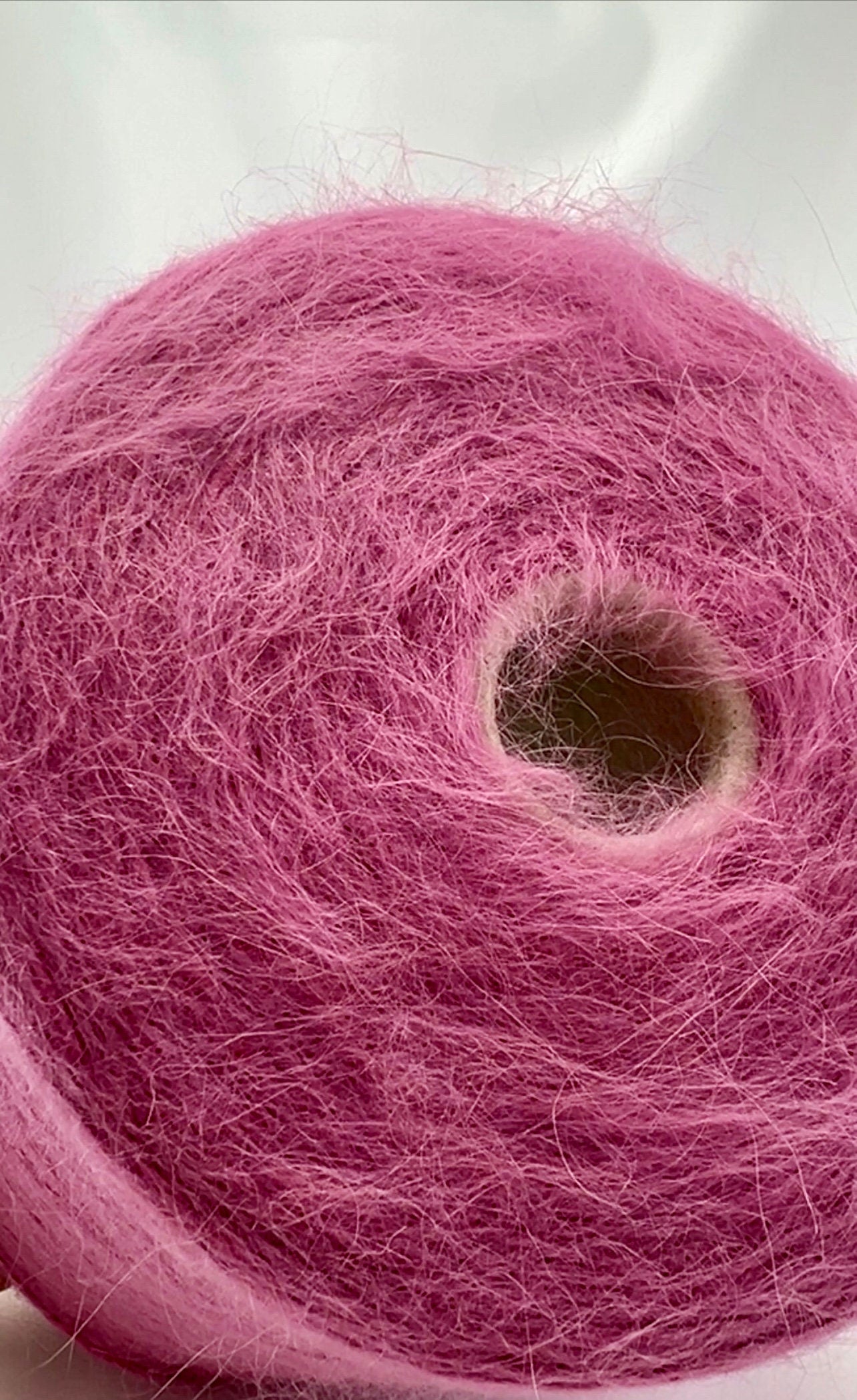 Close-up of a pink skein of yarn on a white background