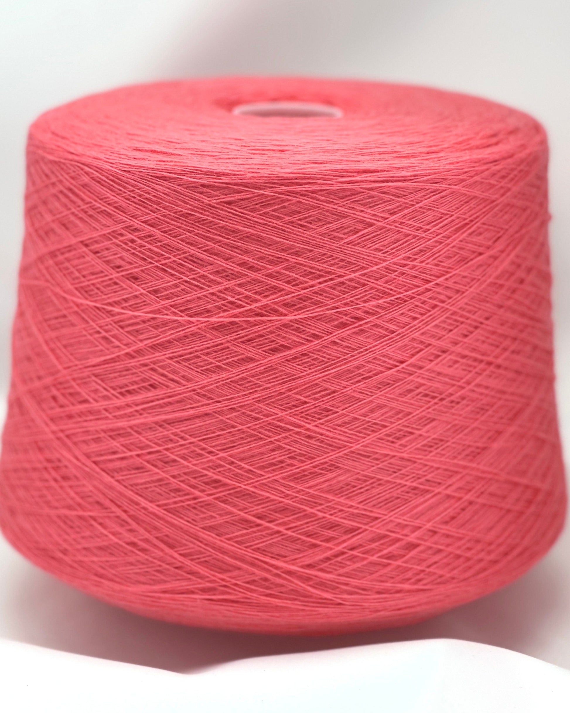 Spool of pink yarn on a white background