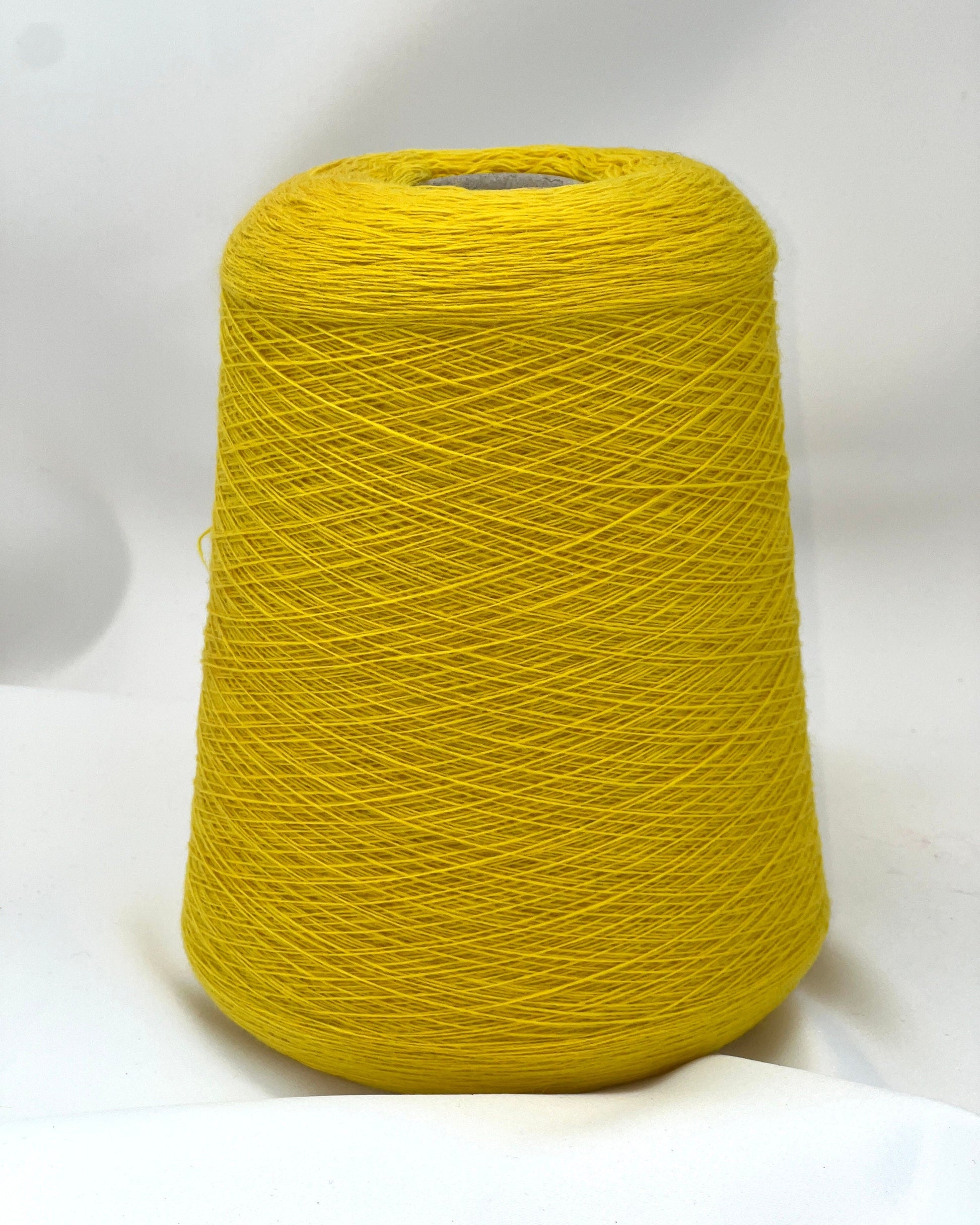 Yellow spool of yarn on a white background