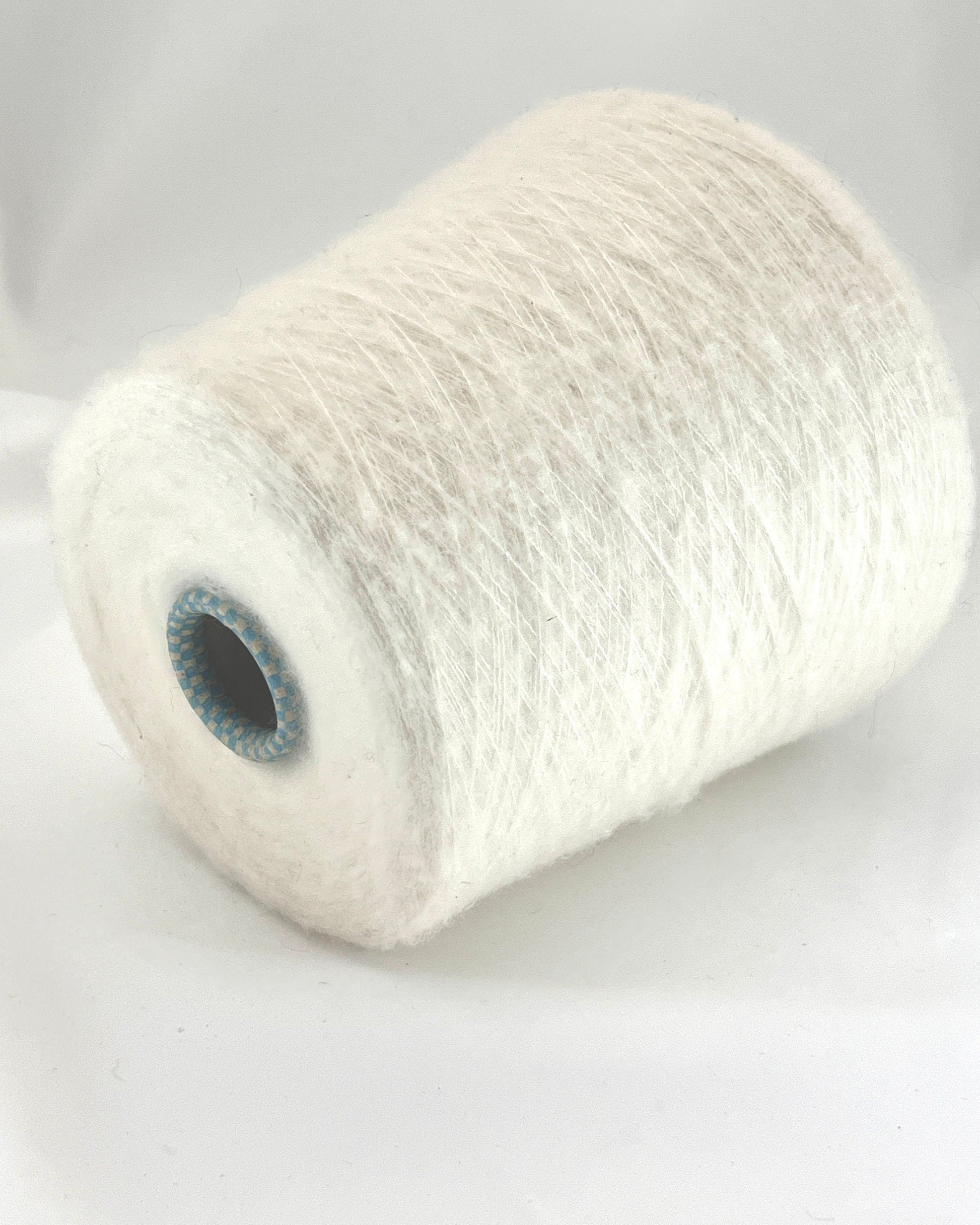 Spool of white yarn on a light gray background