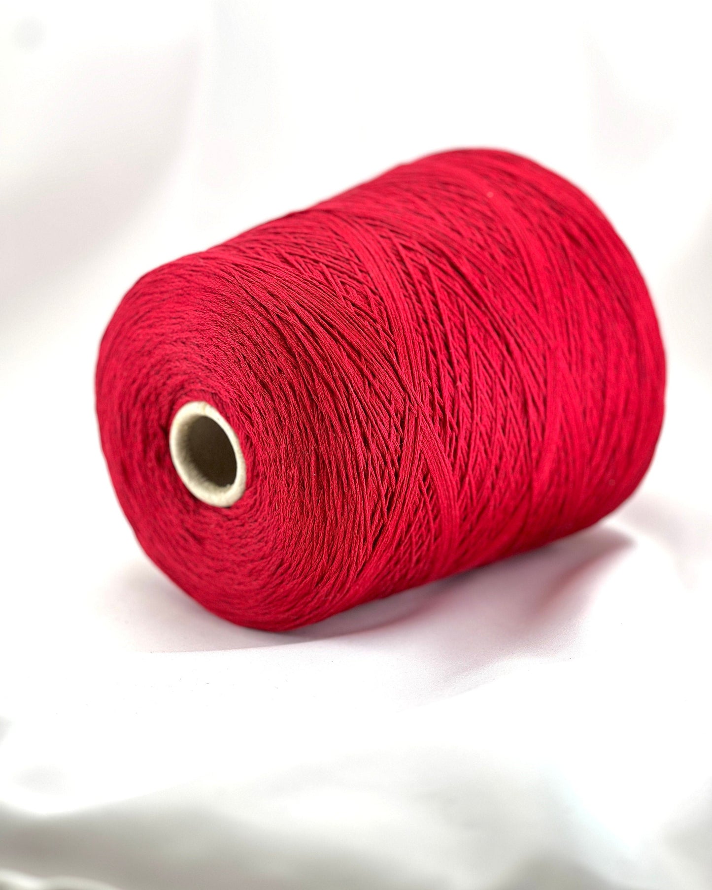 Red spool of thread on a white background