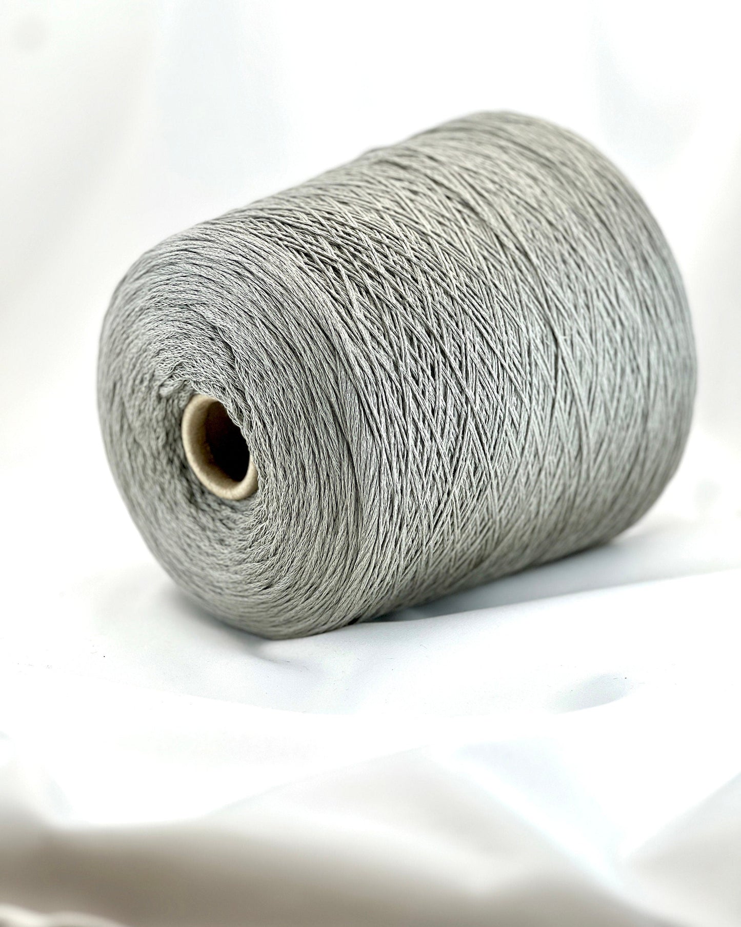Spool of gray yarn on a white background