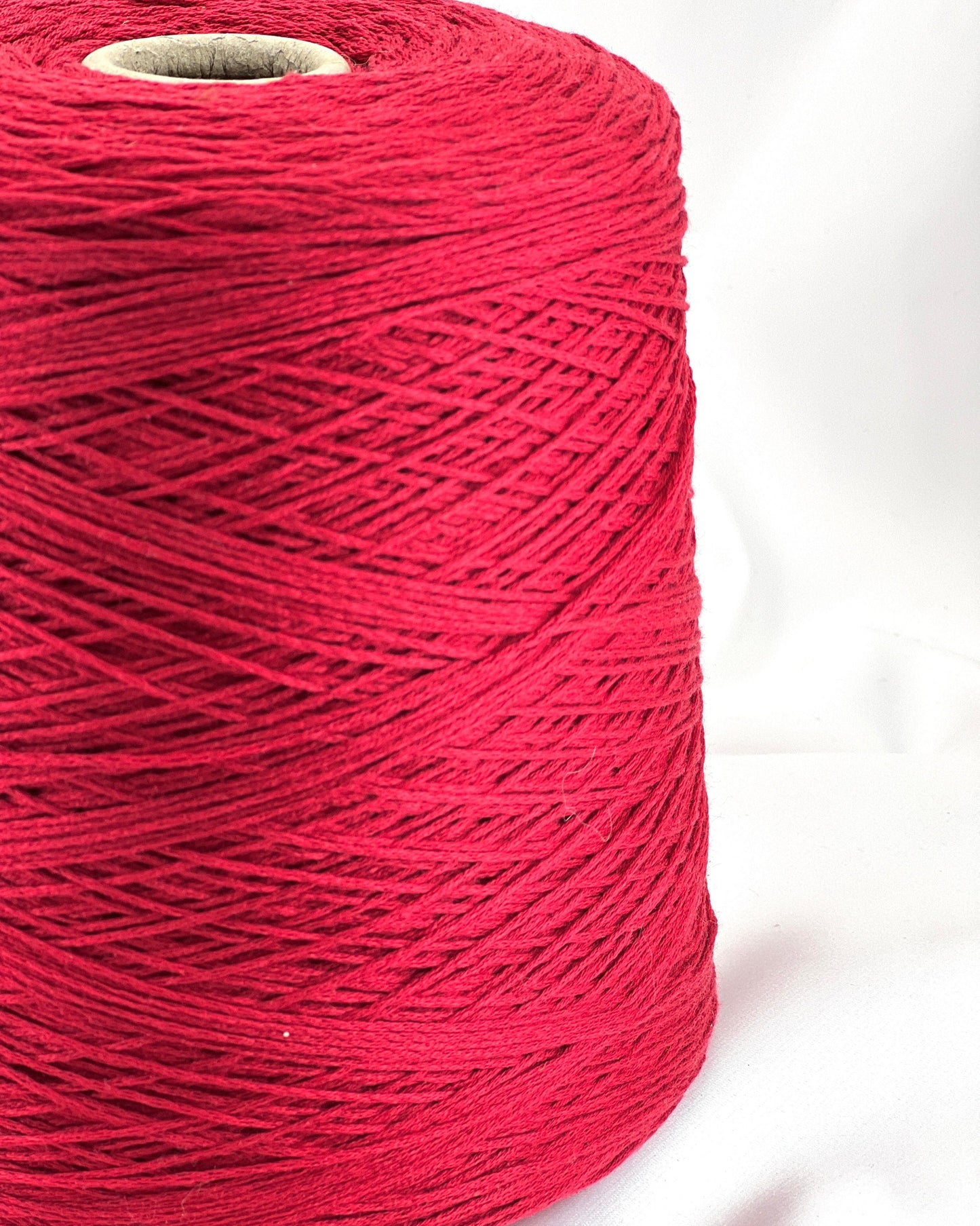 Spool of red thread on a white background
