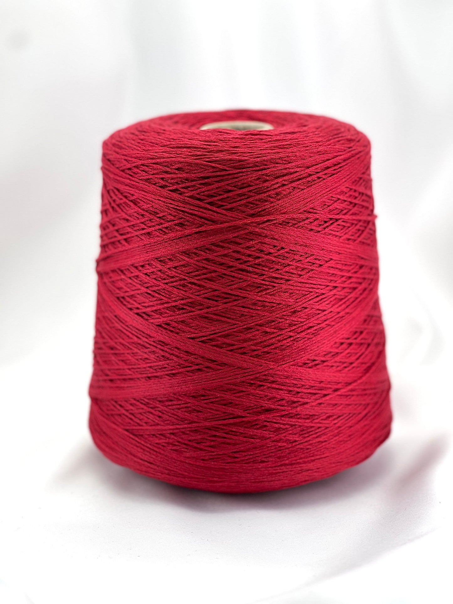 Red spool of yarn on a white background
