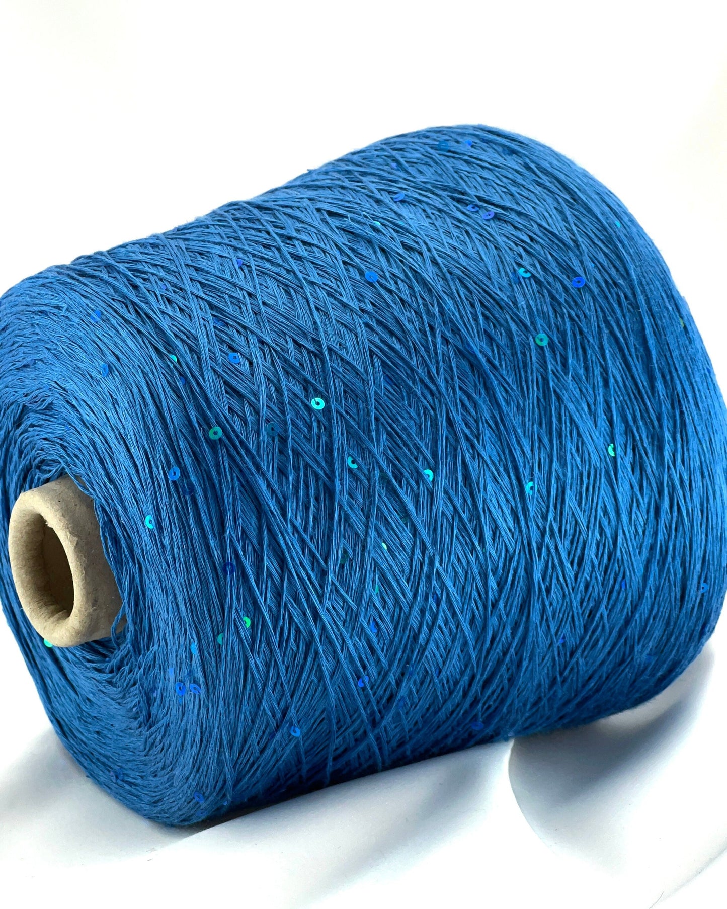 Blue spool of yarn on a white background