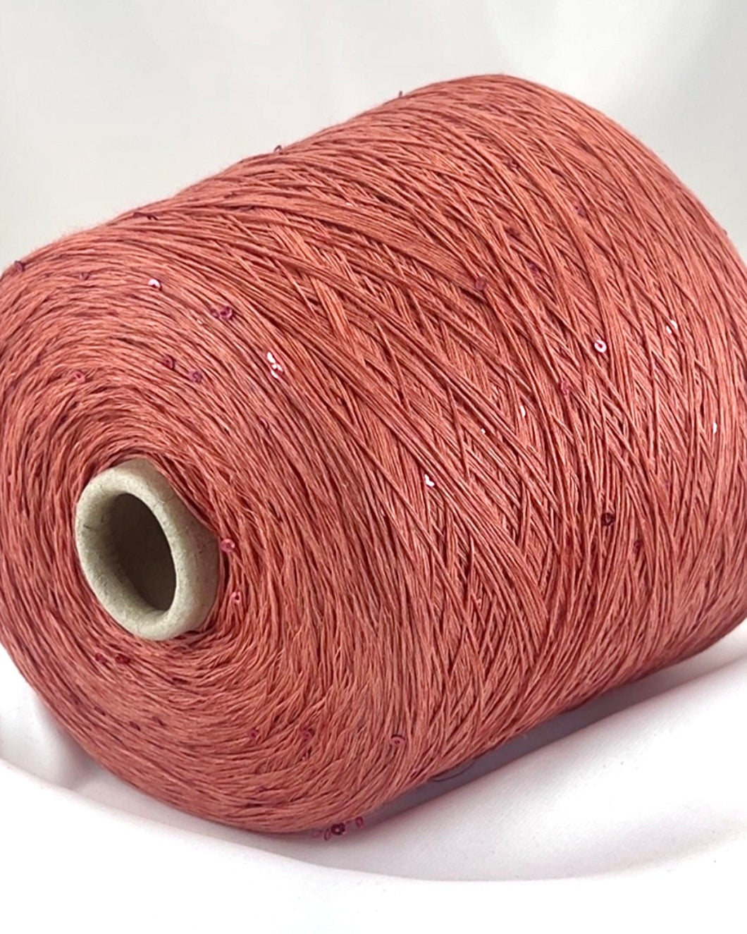 Spool of red yarn on a white background