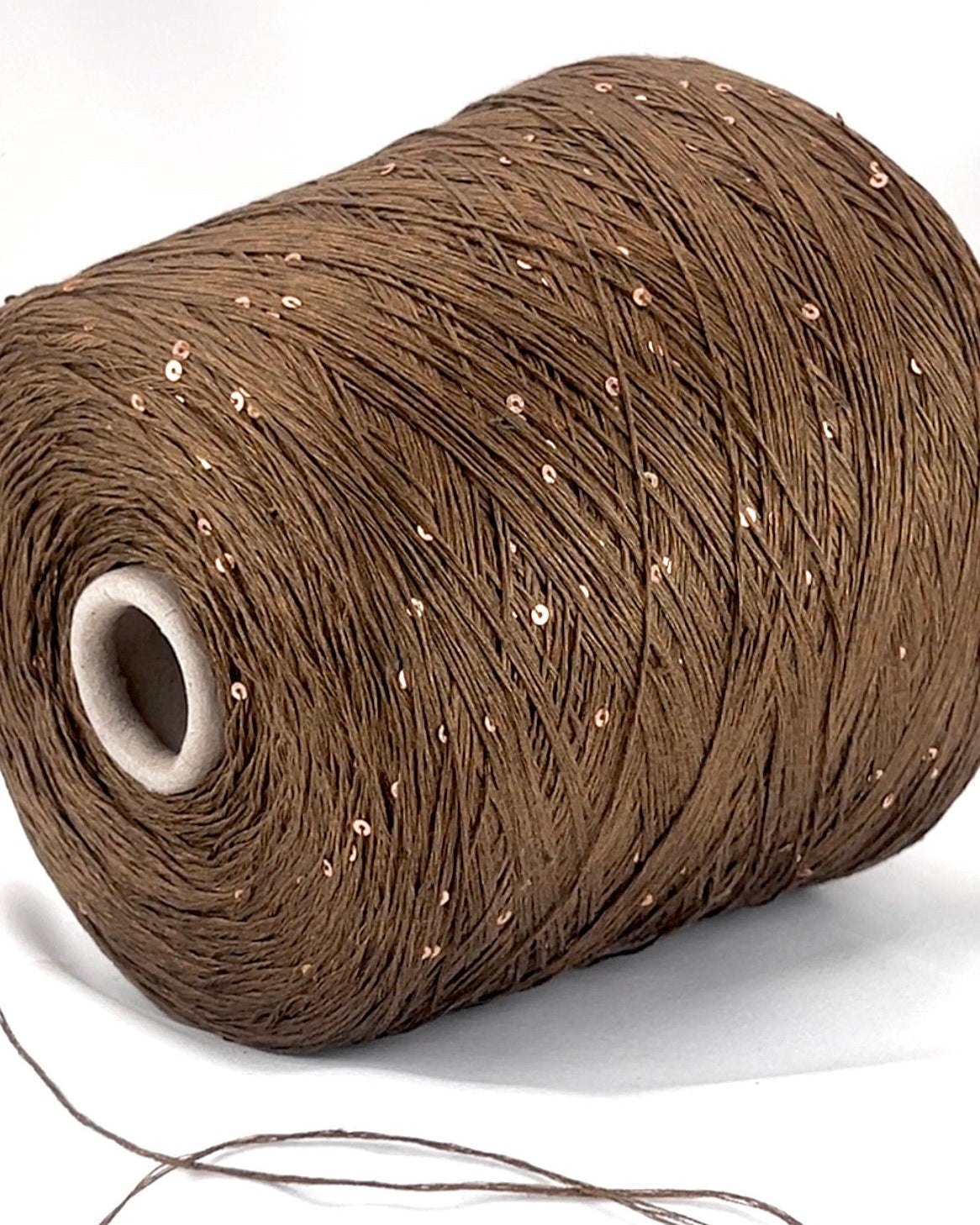Brown spool of thread with sequins on a white background