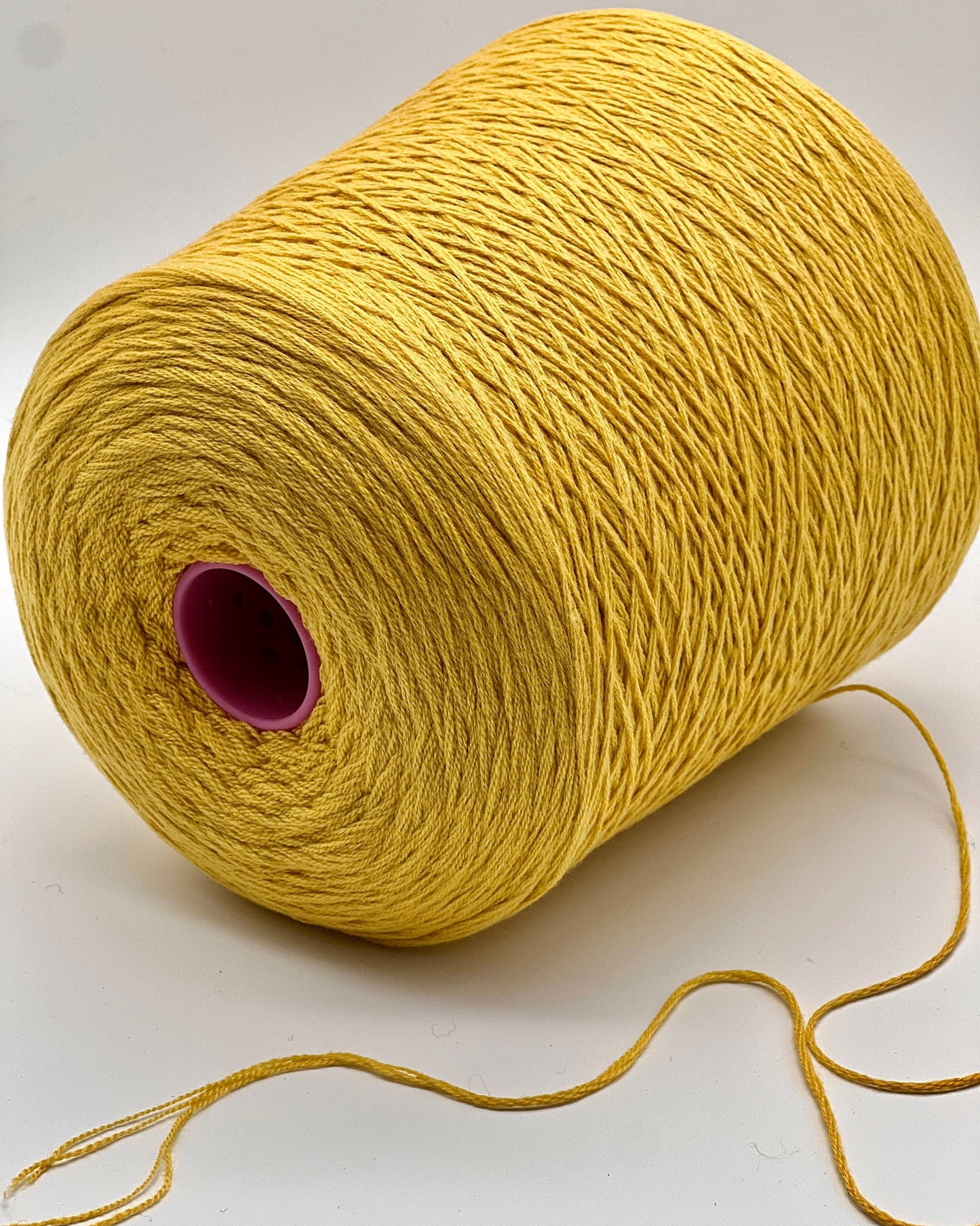 Yellow spool of yarn on a white background