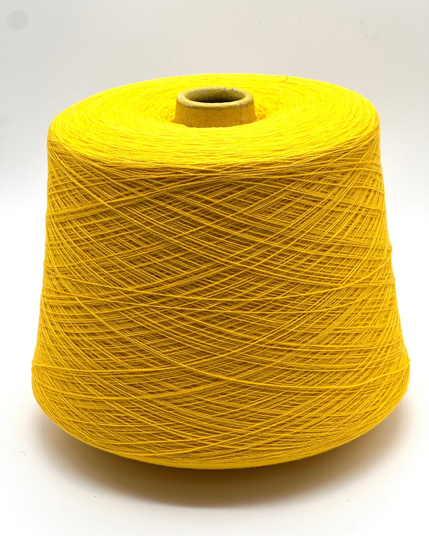 Yellow spool of thread on a white background