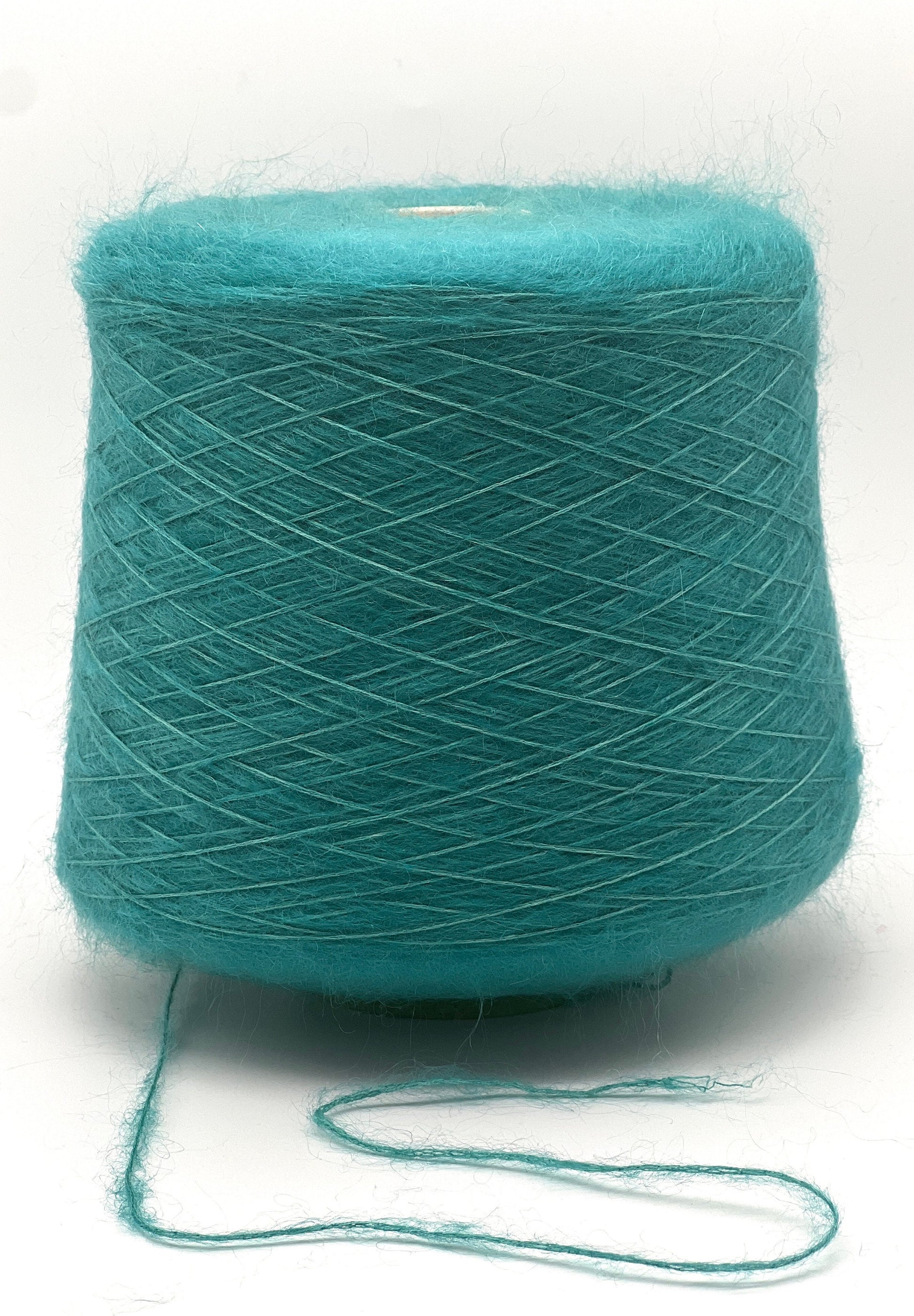 Turquoise yarn spool on a white background