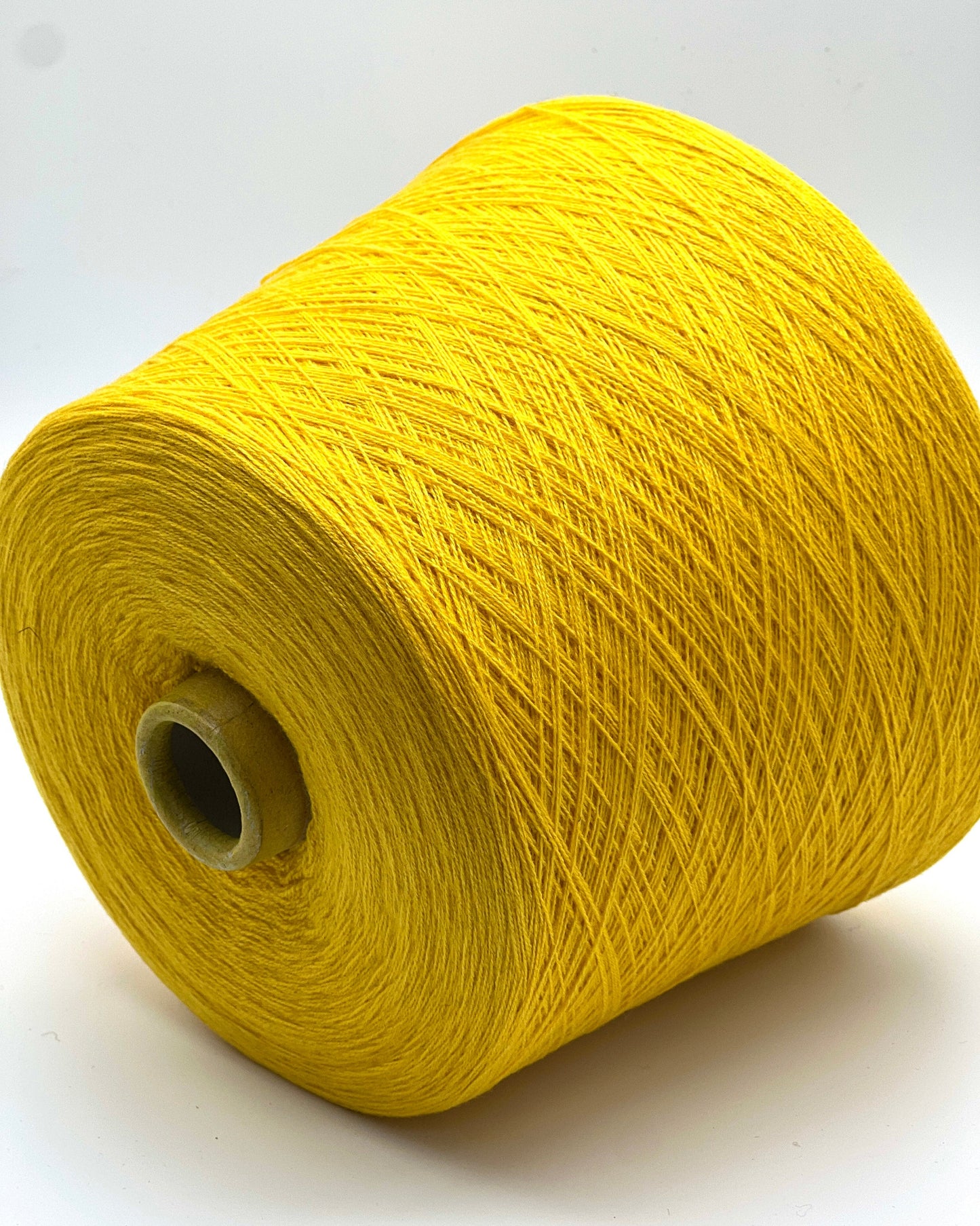 Yellow spool of yarn on a white background