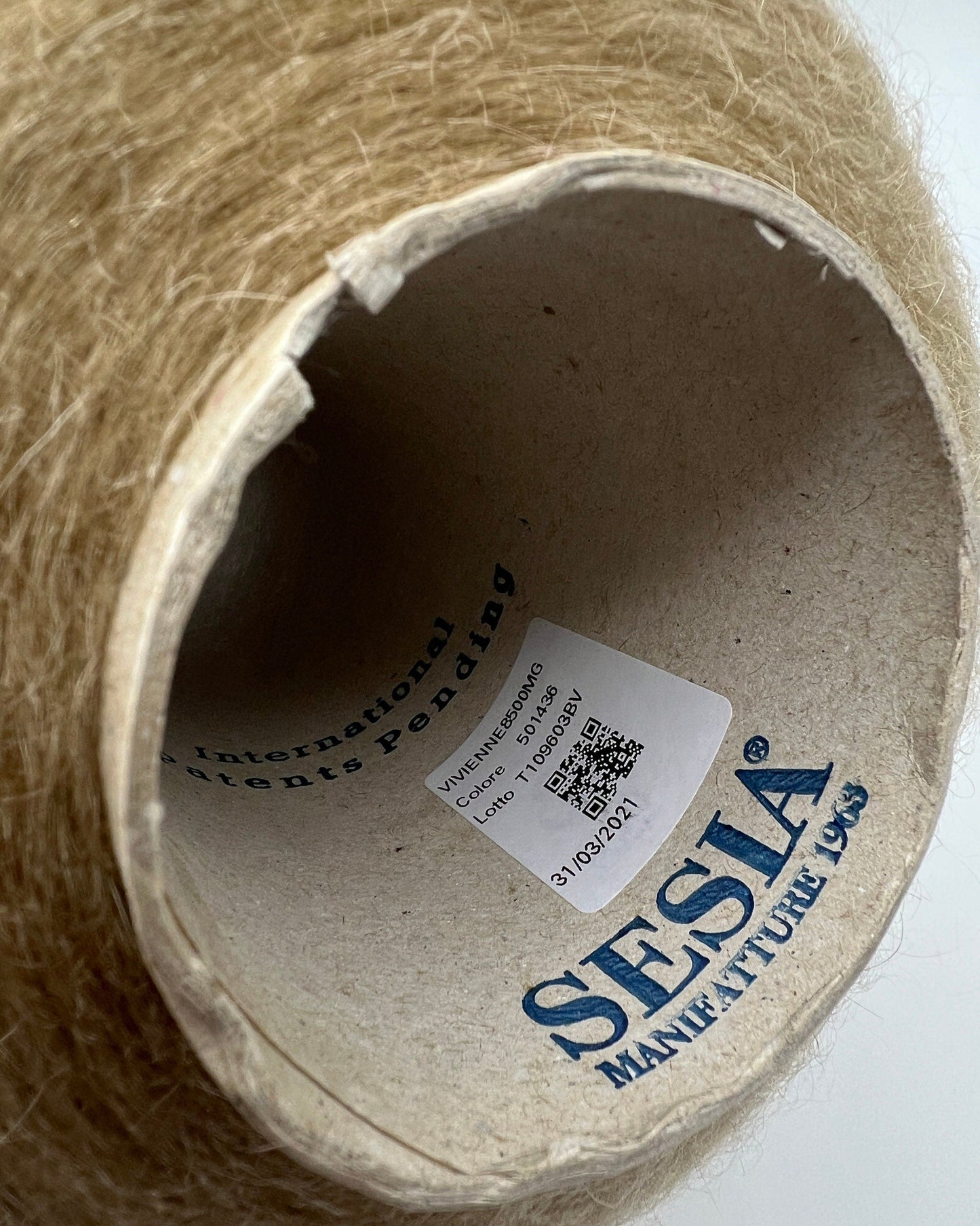 Close-up of a cardboard spool with 'Sesia' branding and a label inside.