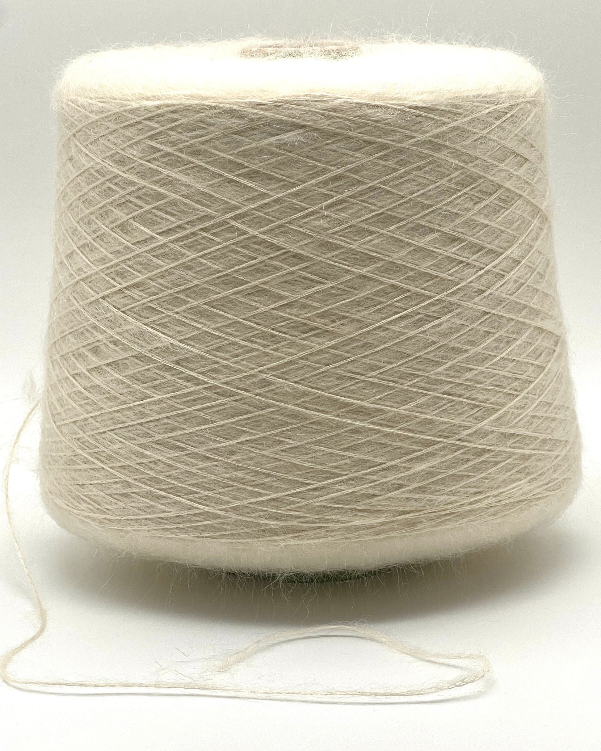Spool of beige yarn on a white background