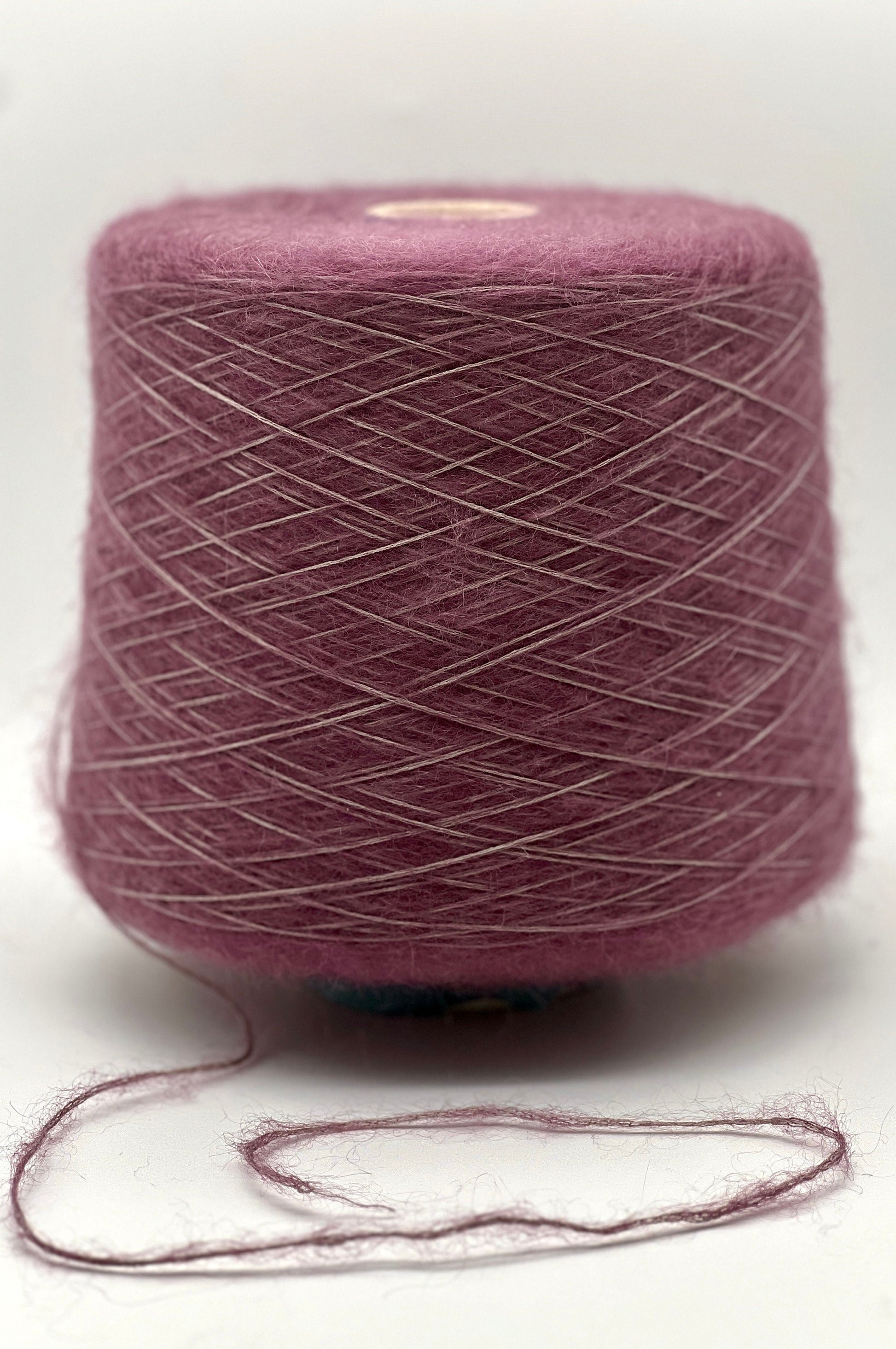 Ball of purple yarn on a white background