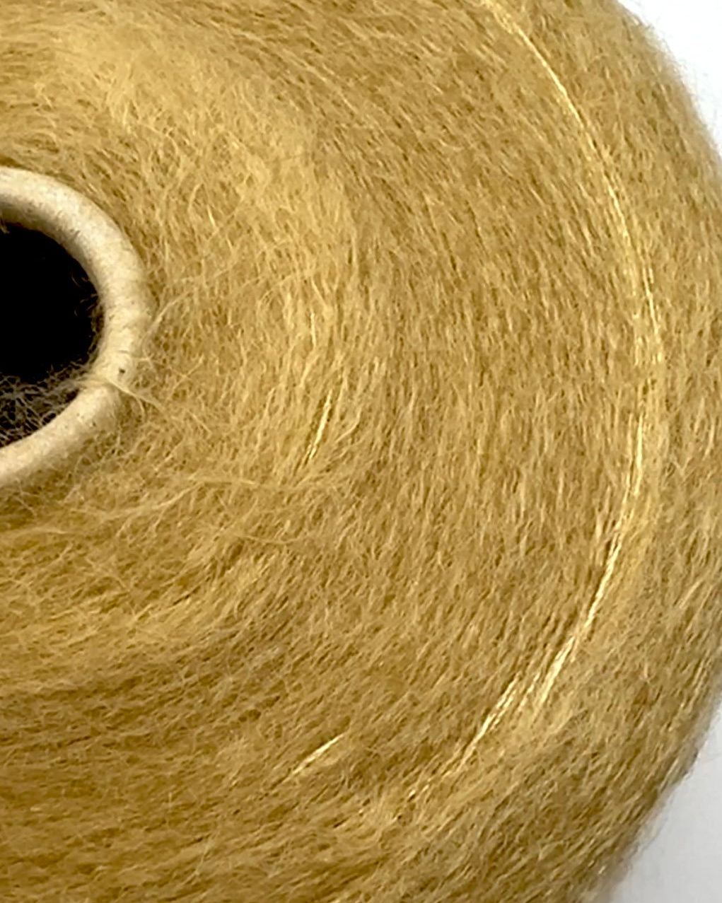 Close-up of a ball of gold yarn on a white background