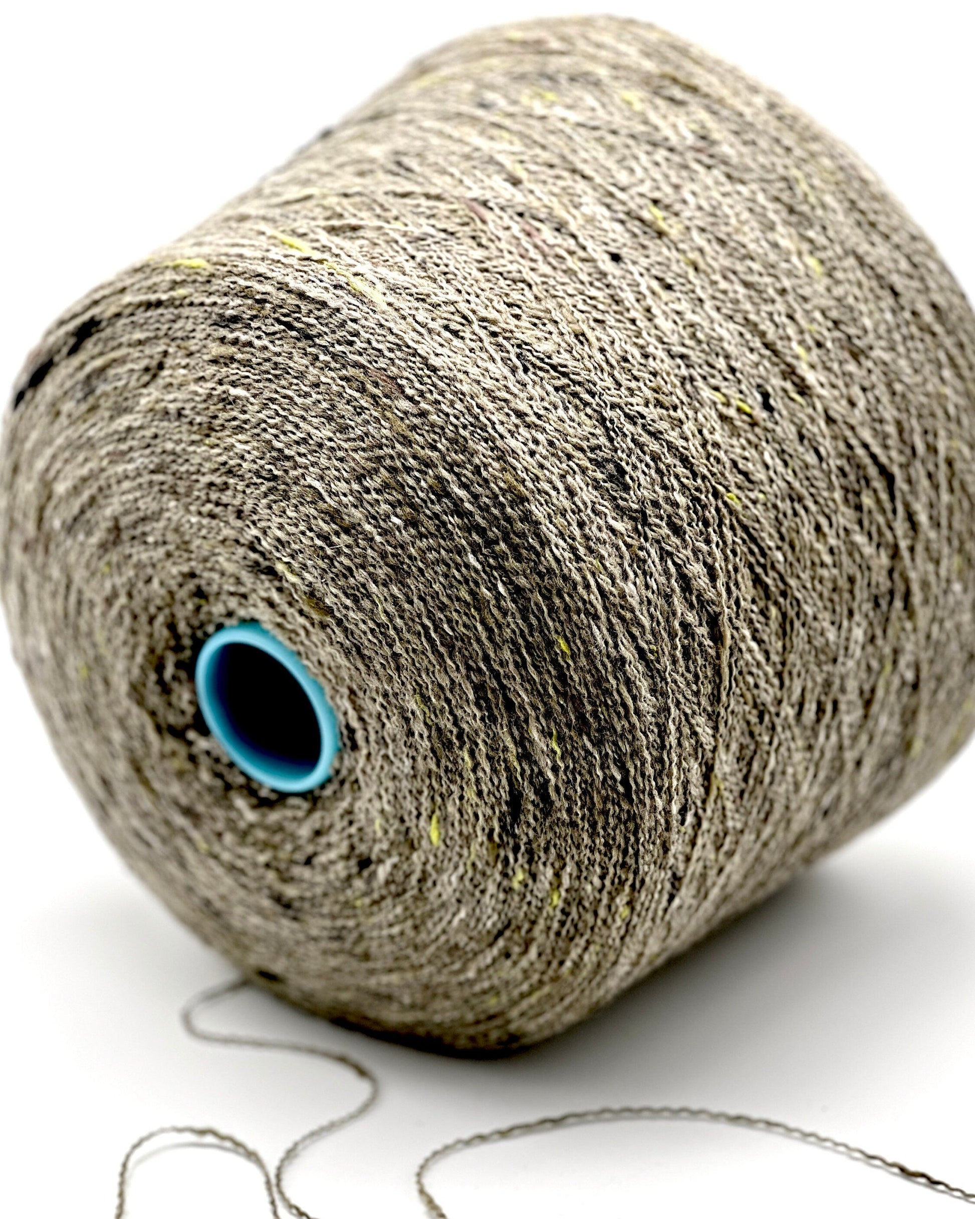 Spool of gray yarn with a blue core on a white background