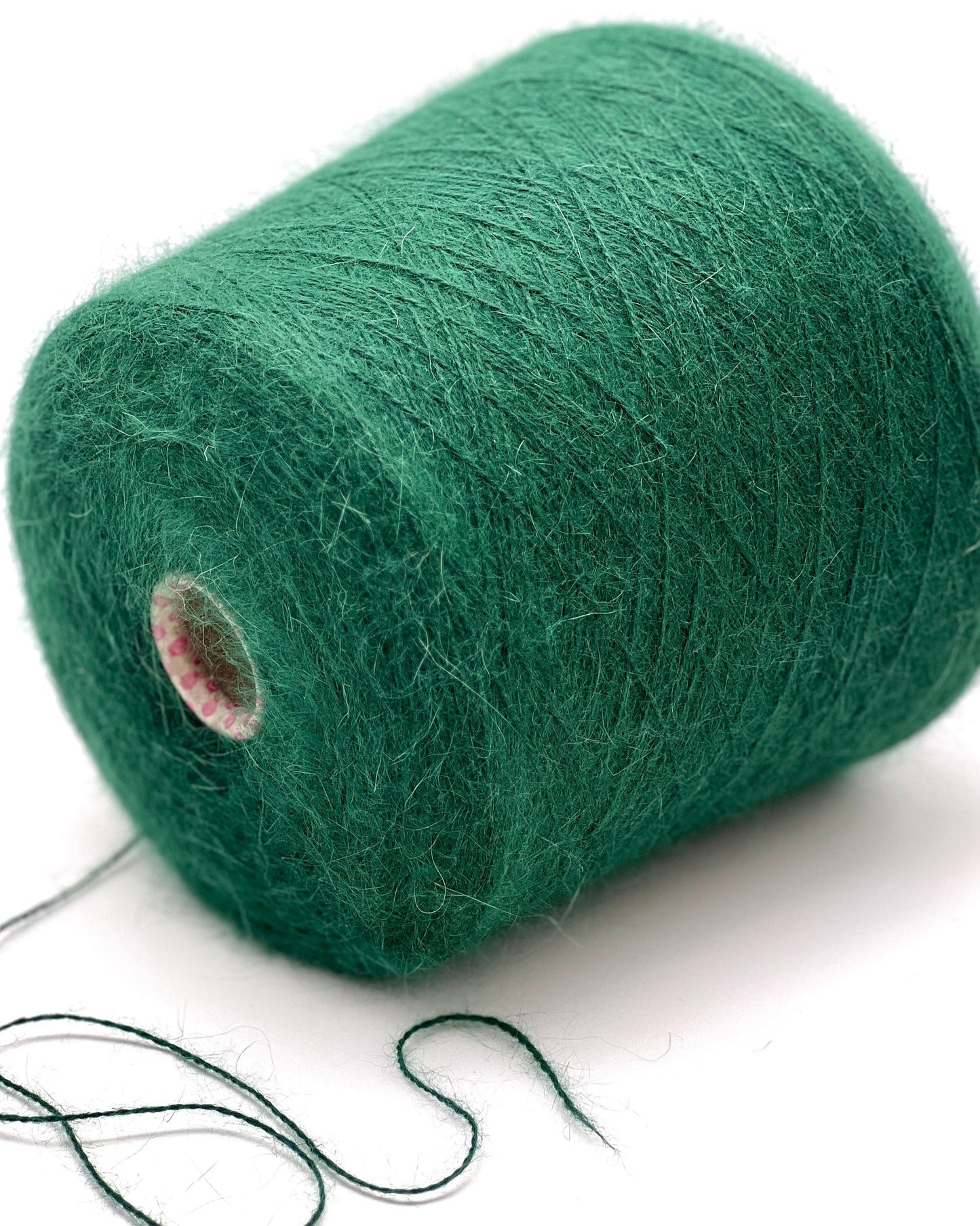 Green yarn spool on a white background