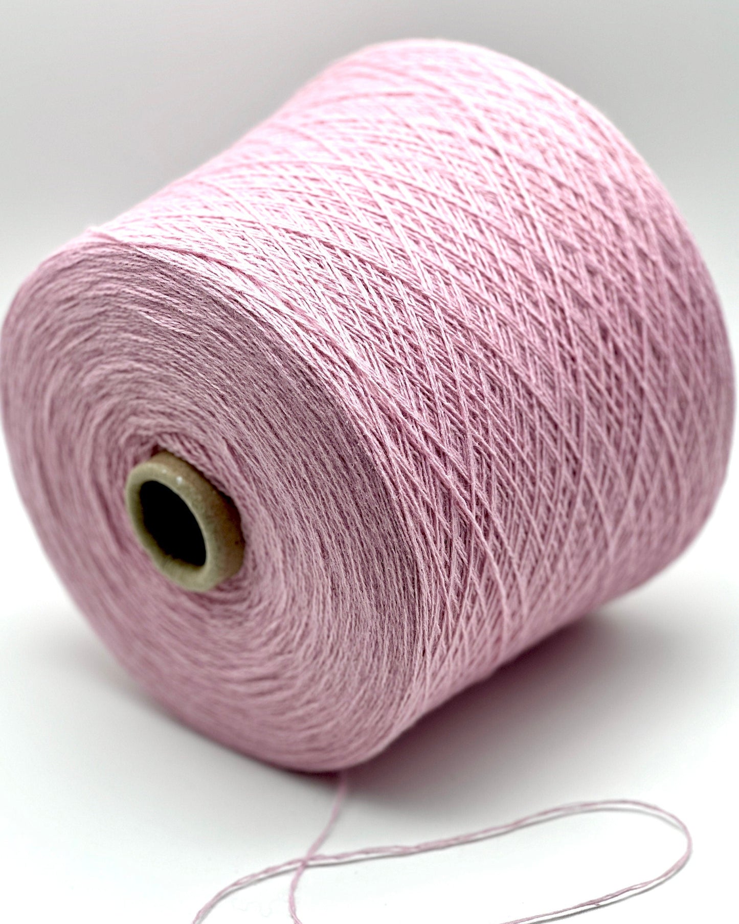 Pink spool of yarn on a white background