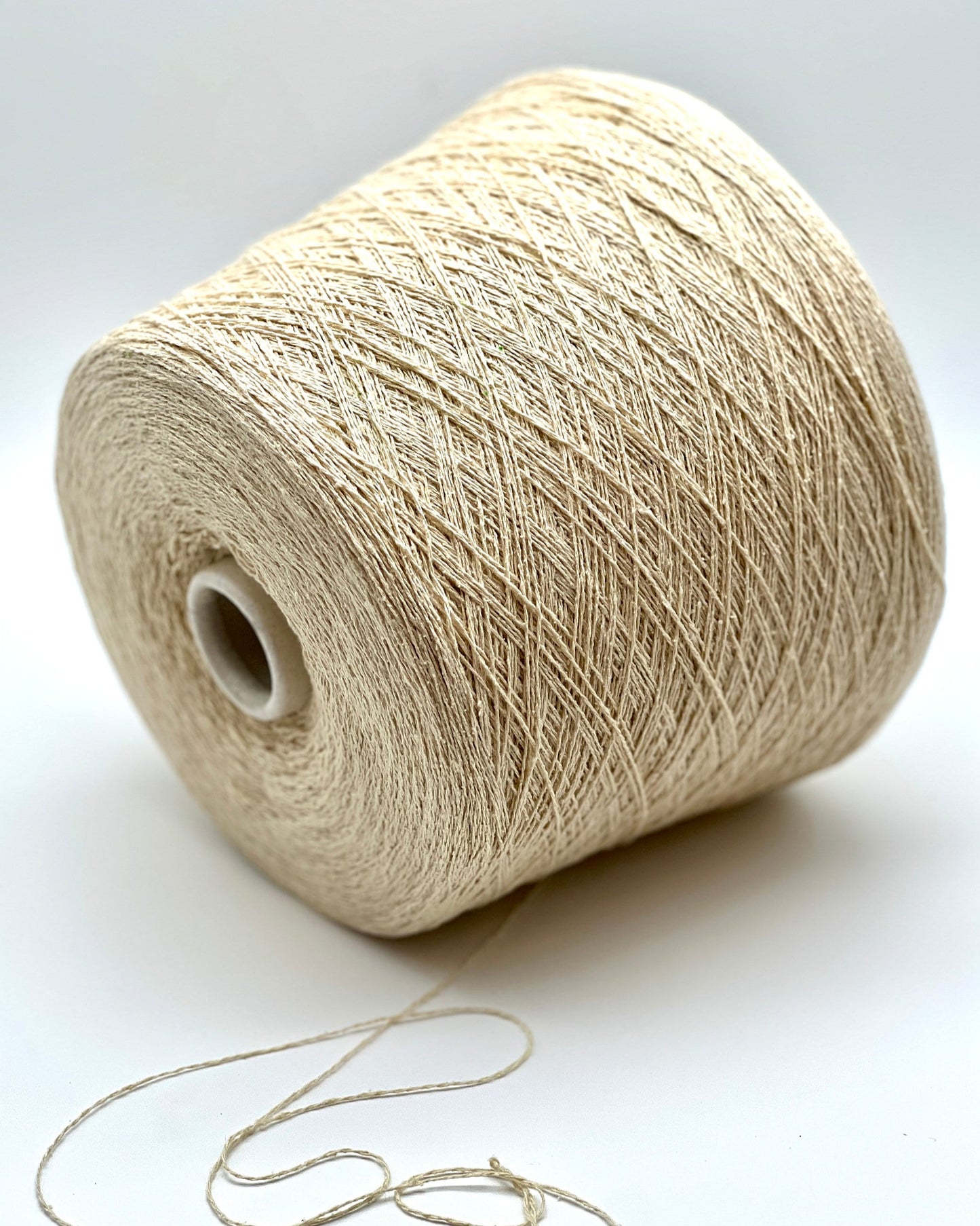 Spool of beige yarn on a white background