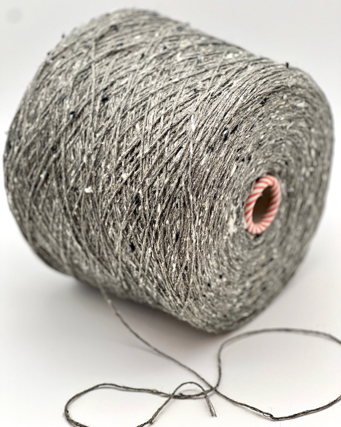 Ball of gray yarn with a pink knot on a white background