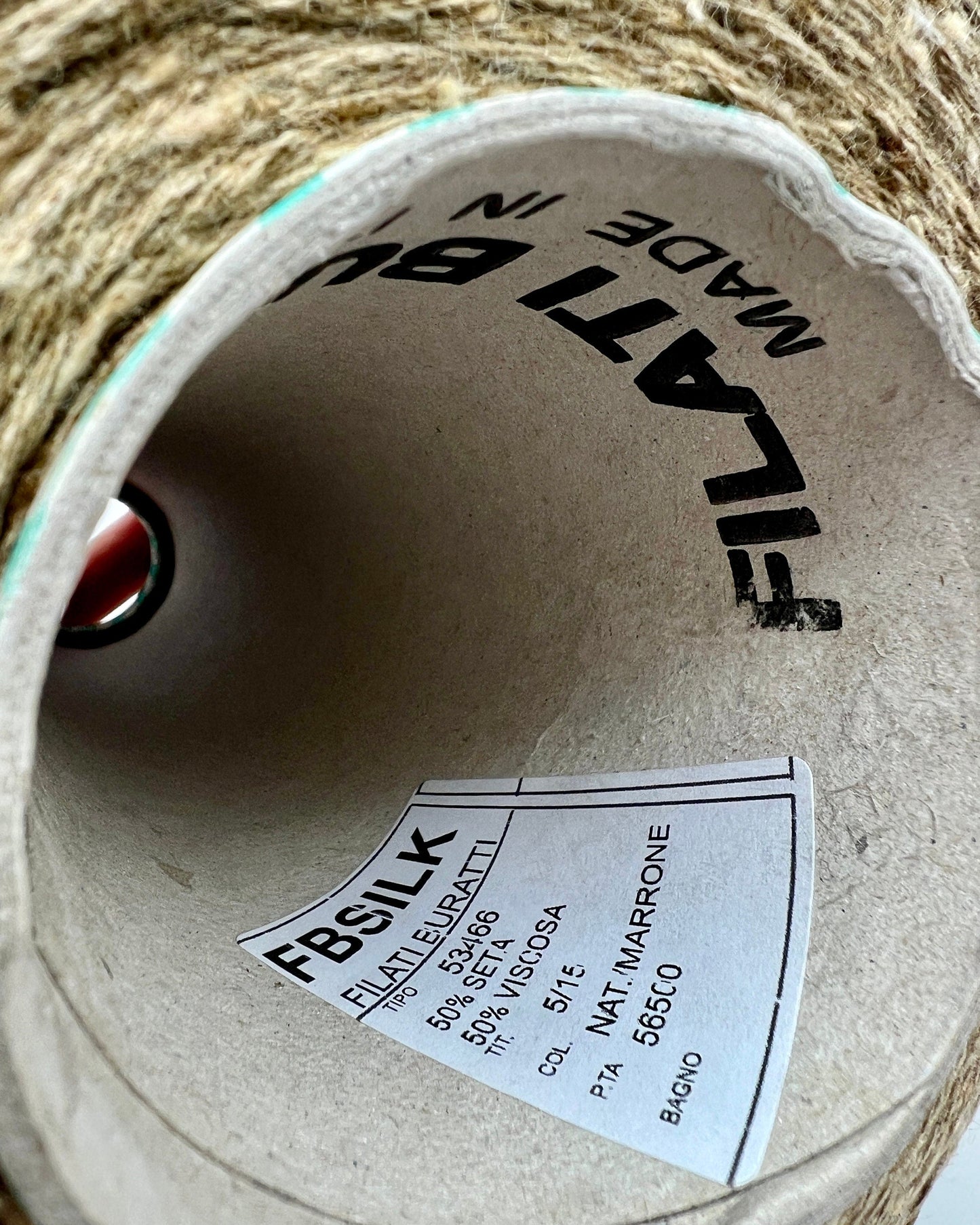 Close-up of a spool of Filattelli yarn with a label inside.
