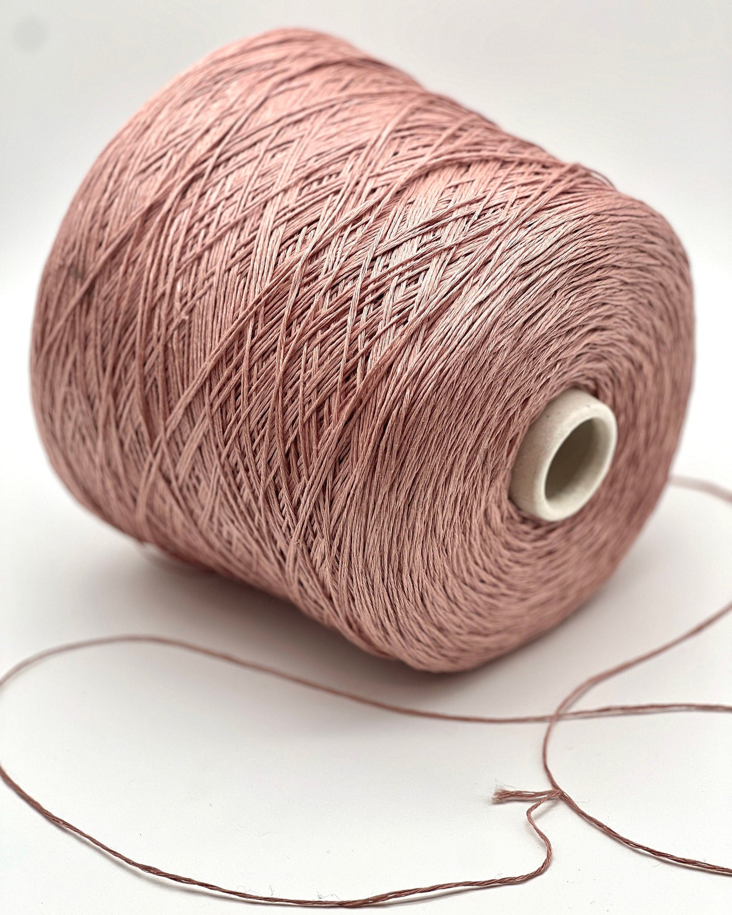 Spool of pink yarn on a white background