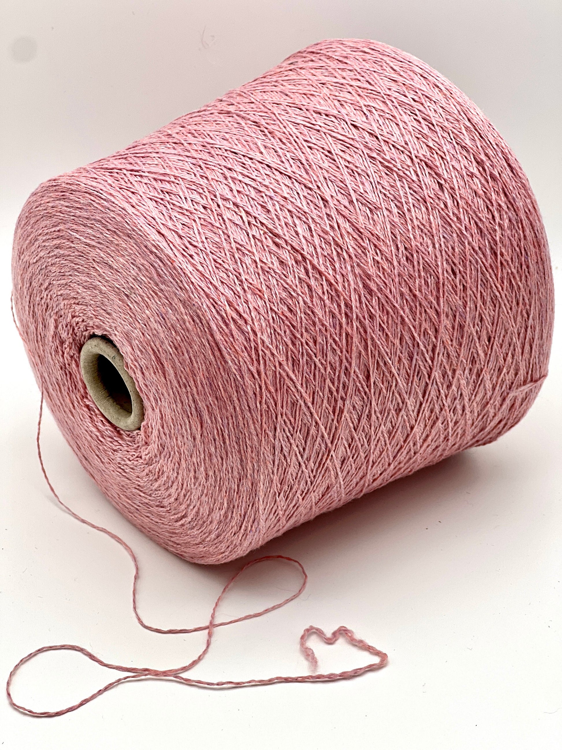 Pink spool of yarn on a white background