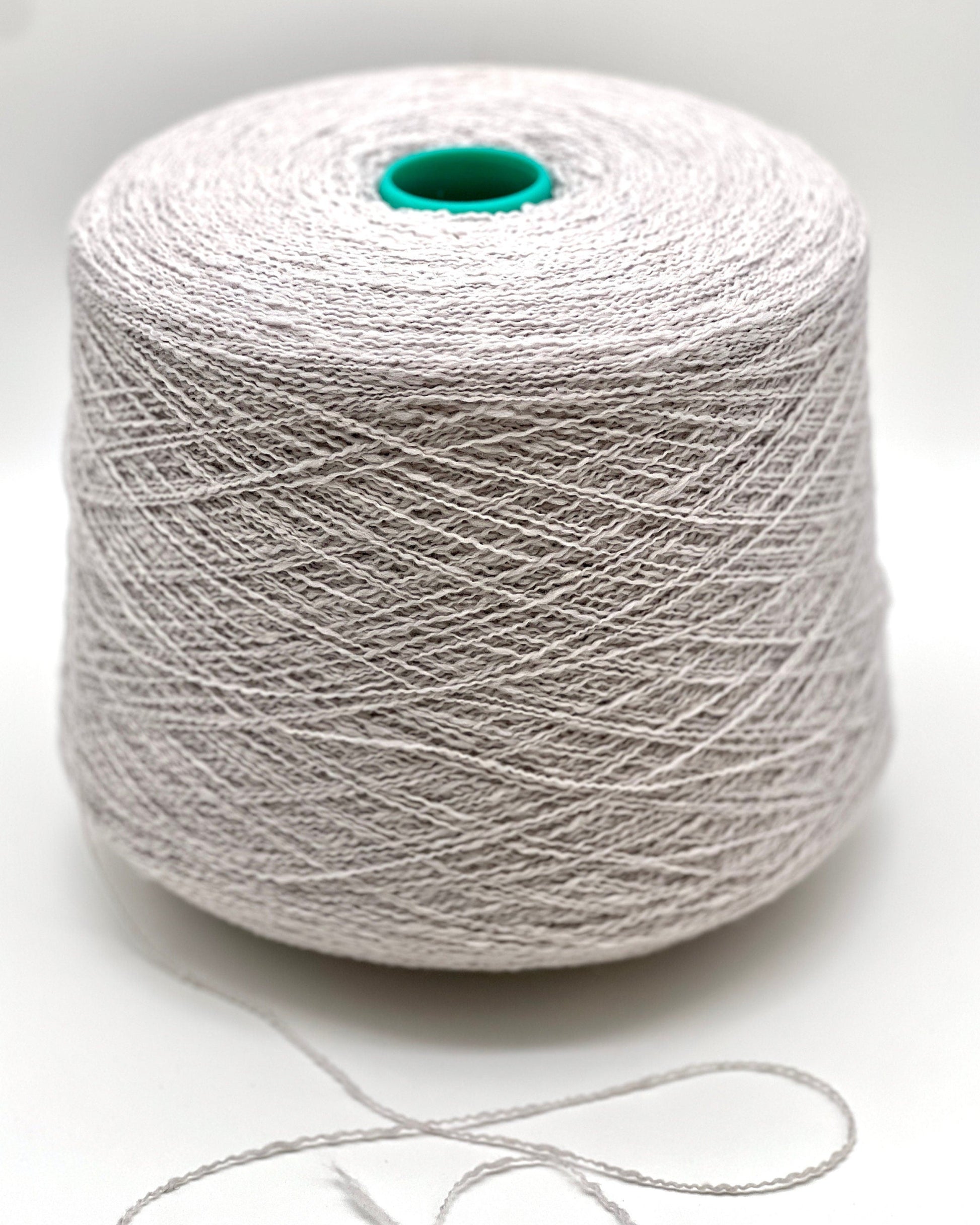 Spool of white yarn on a light gray background