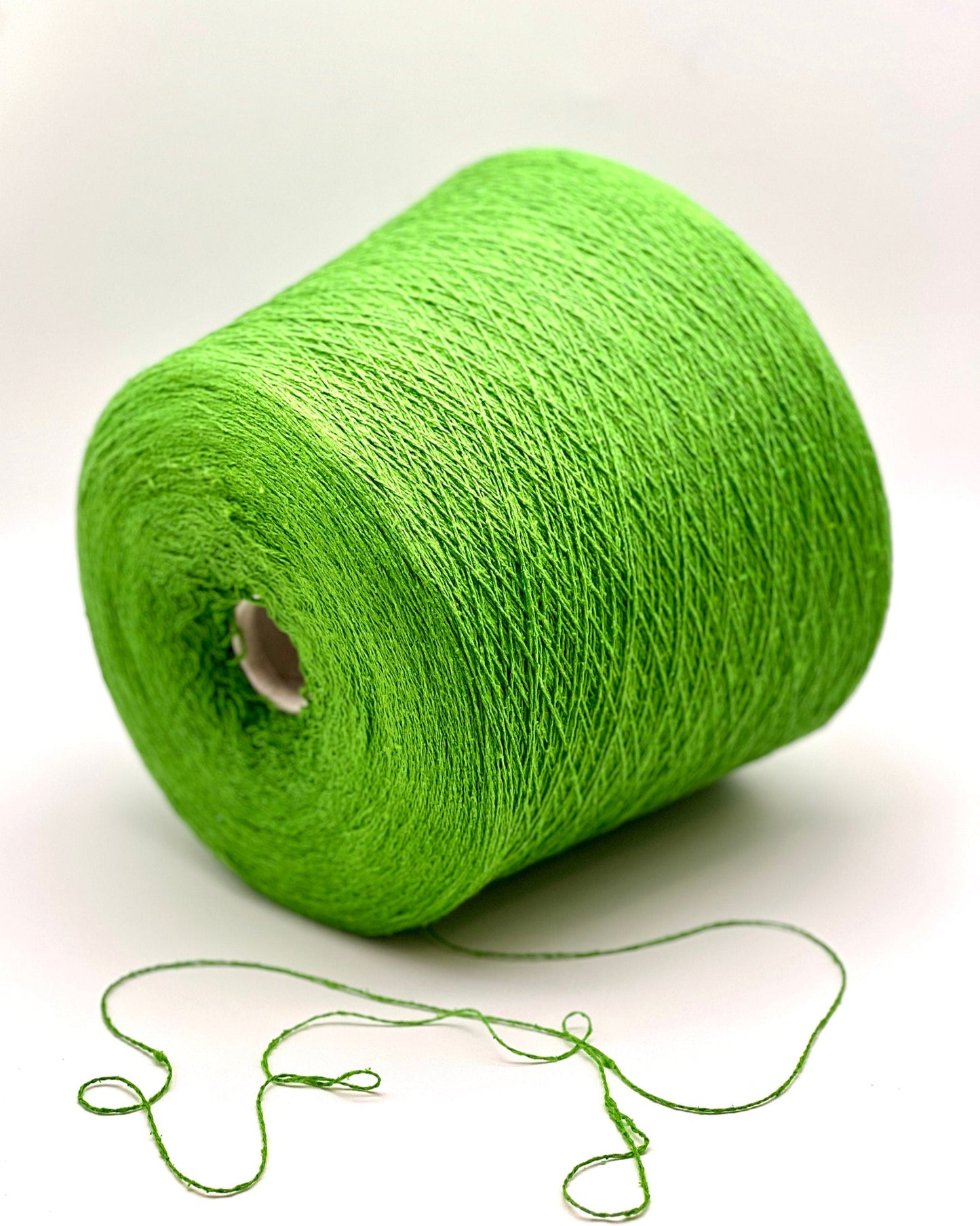 Green spool of yarn on a white background