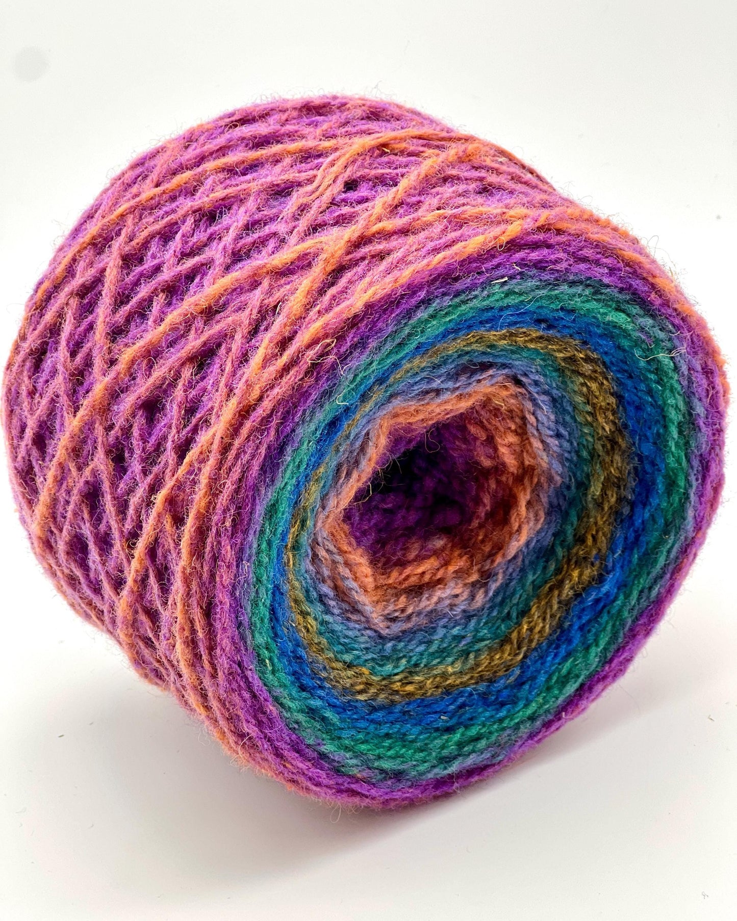 Colorful yarn wound into a center-pull cake, demonstrating the iDOKNiT custom winding service.